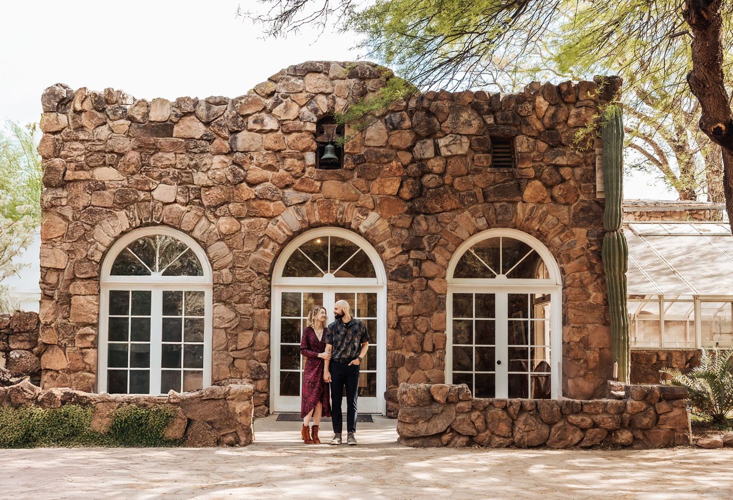 Historic stone building with rustic exterior featuring three arched windows and a central entrance.