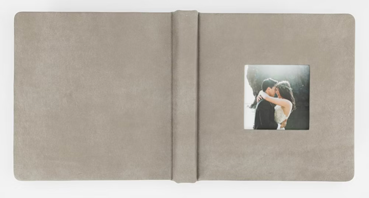 A small square photograph situated in the center of an open beige colored photo album or scrapbook page.