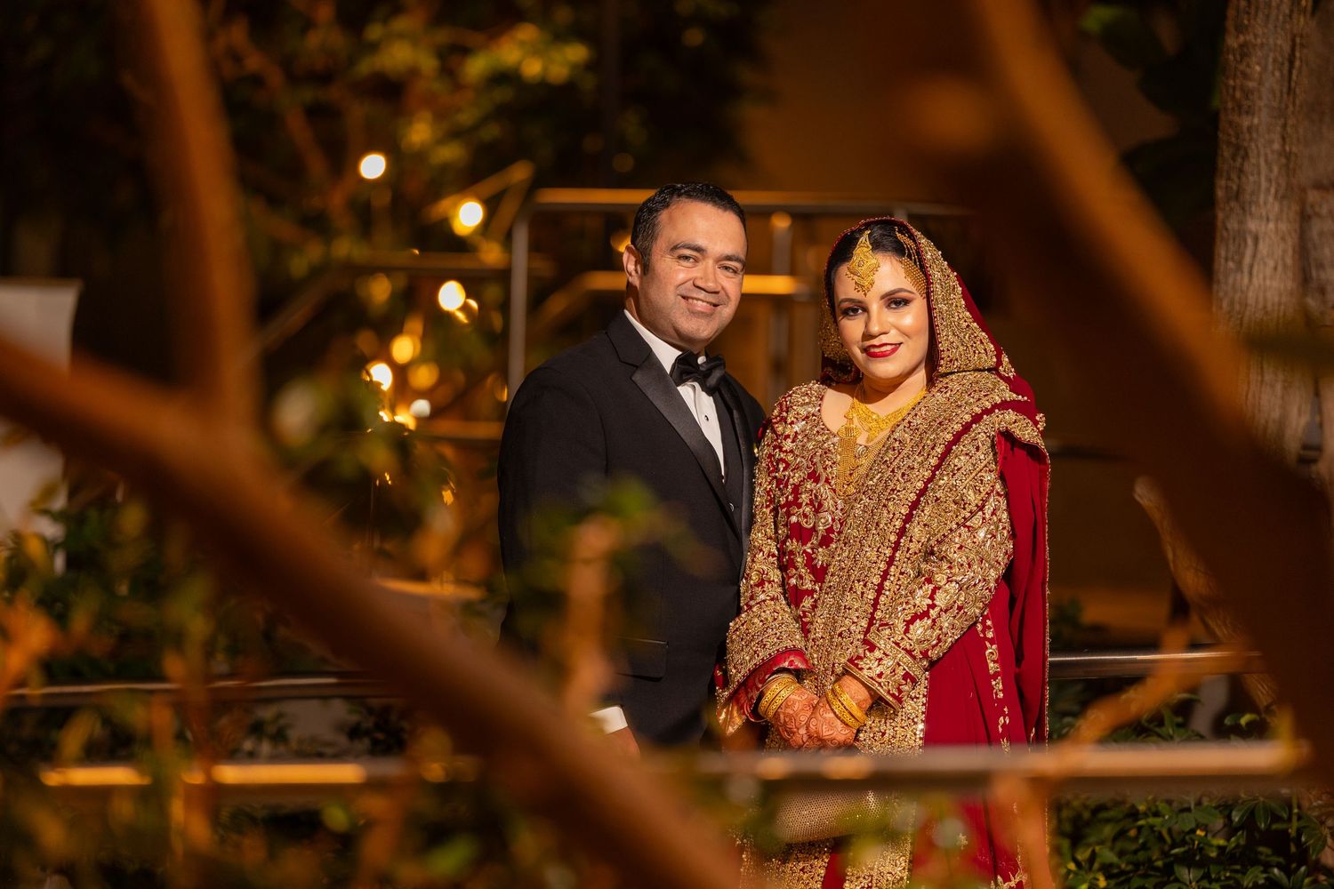 A wedding celebration at night with warm lighting and traditional Indian attire creating a romantic ambiance.