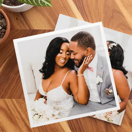 A romantic black and white collage of a couple in wedding attire laying on a hardwood floor.