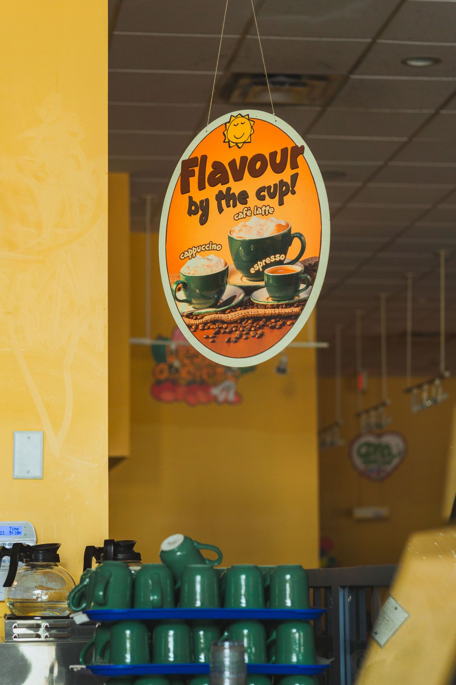 Warm and welcoming Cora’s breakfast spot with yellow-themed décor with coffee cups in Victoria, Canada