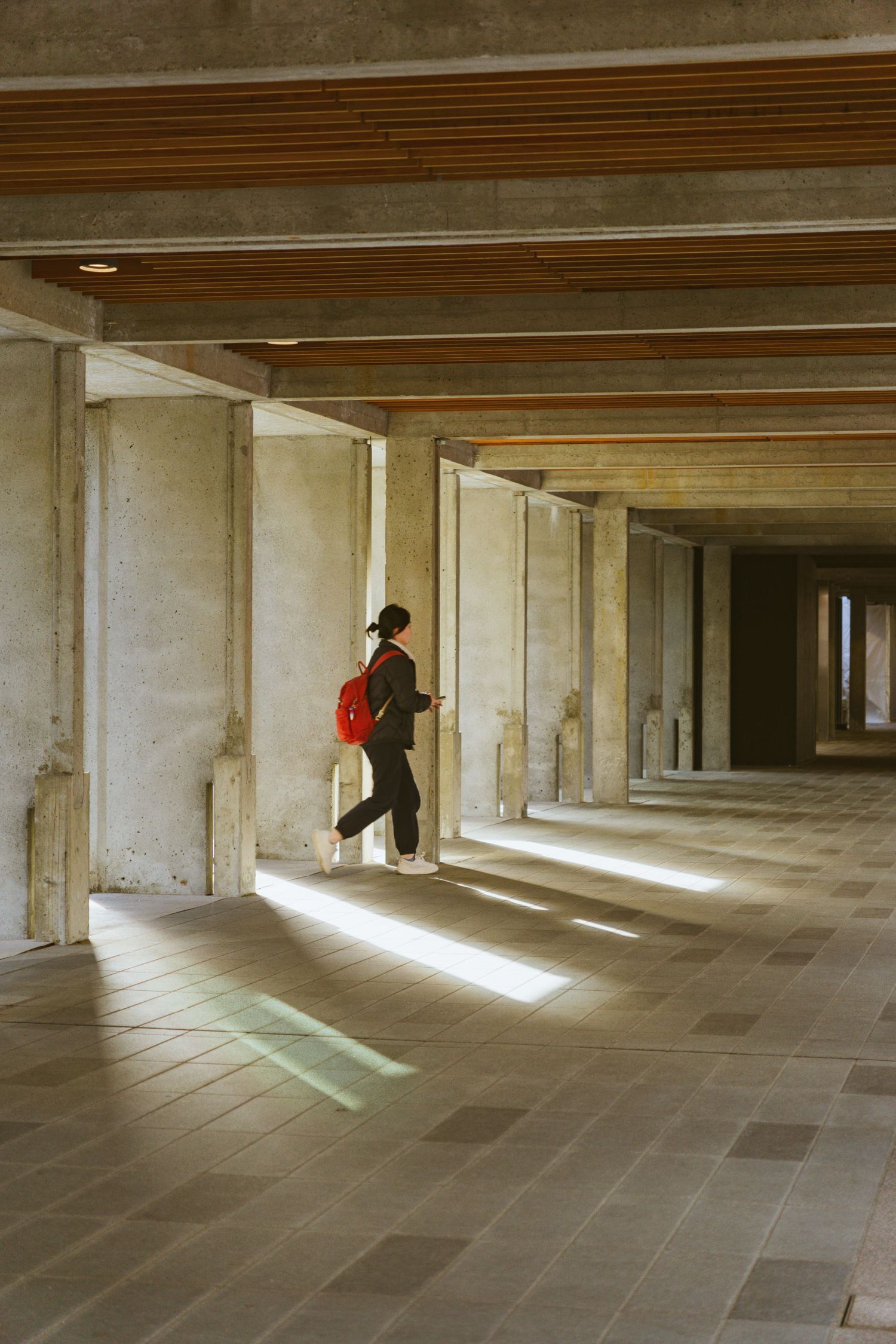 Architectural shot of a Women walking with sunlight coming through in Simon Fraser University, Burnaby, Canada