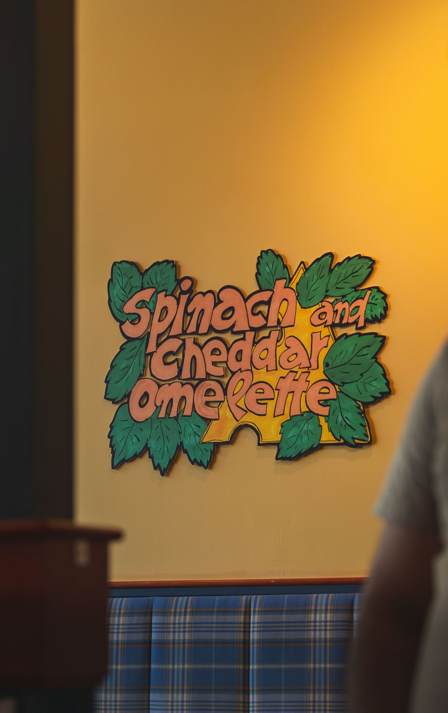 Yellow-toned restaurant wall featuring quirky food-themed quotes at Cora’s Victoria, Canada