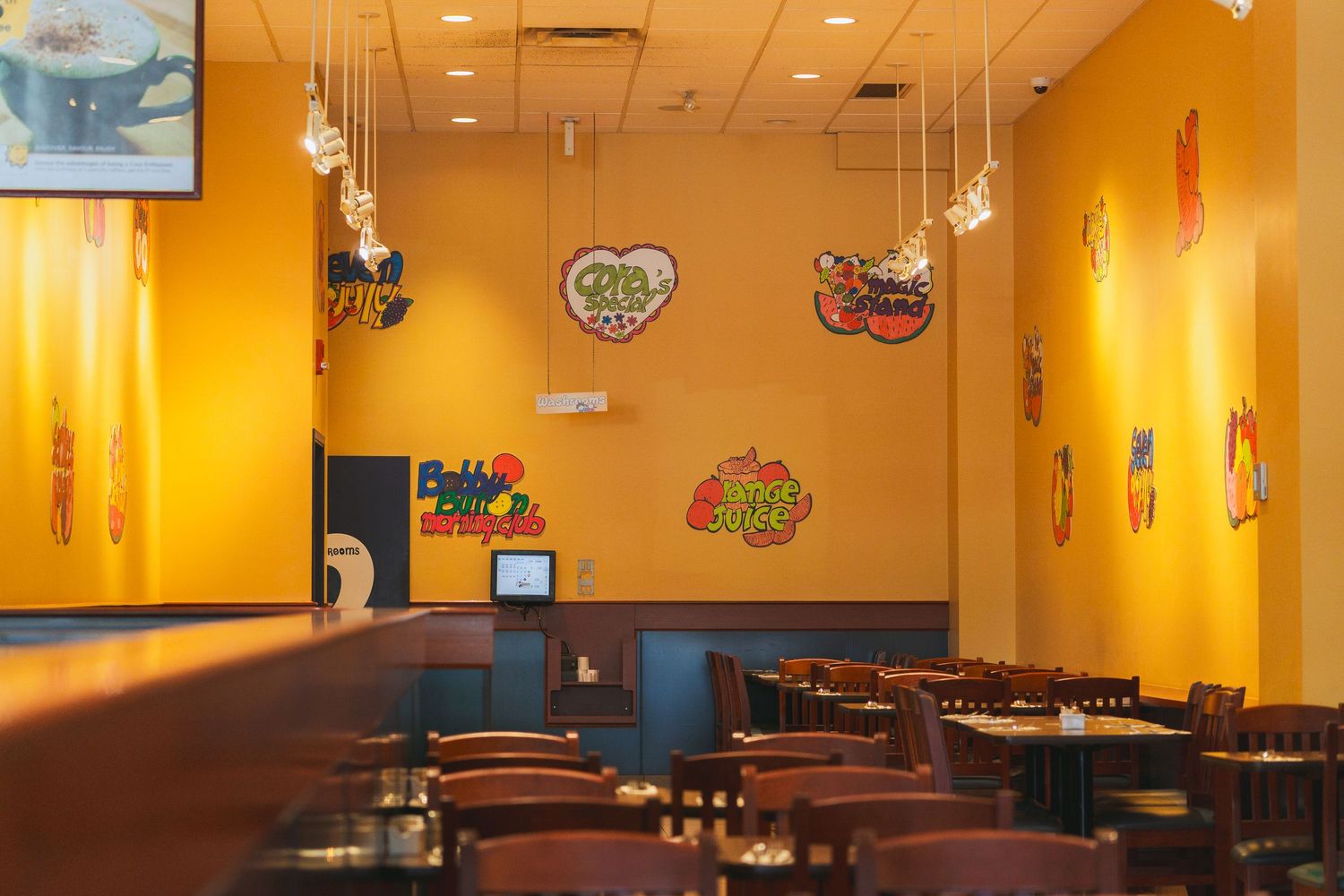 Interior of Cora’s restaurant showing yellow tones and modern breakfast setup in Victoria, Canada