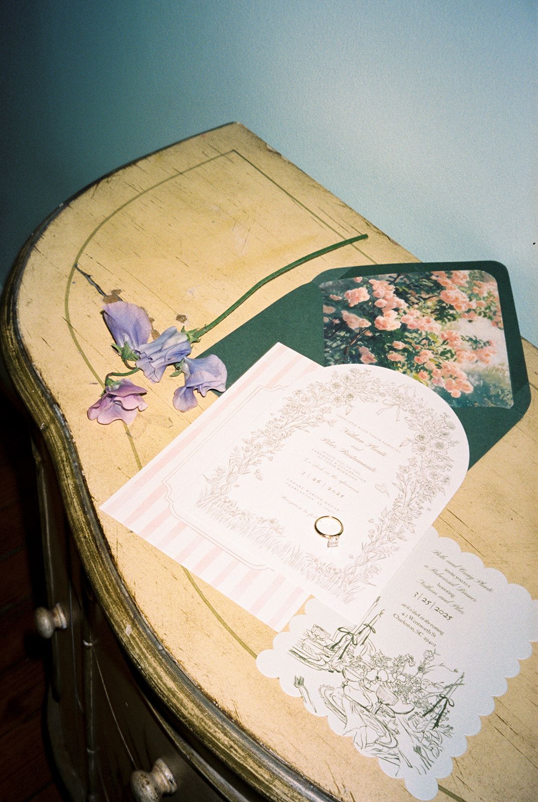 A sequence of eight photos showing an elegant invitation suite with purple iris and floral designs on a light background.