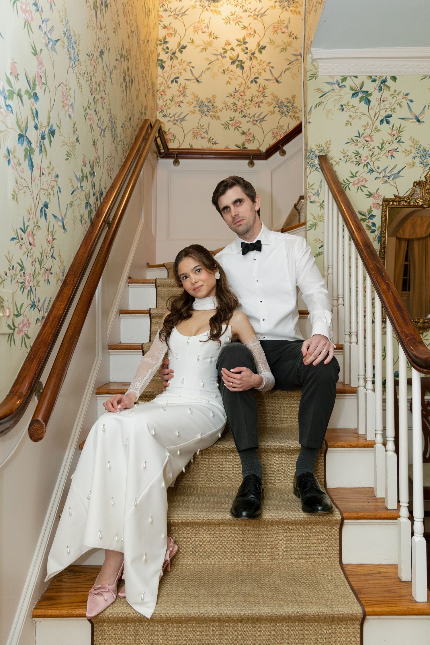 A serene staircase photo set showing artistic poses on carpeted steps with elegant white and floral wallpaper backdrop.