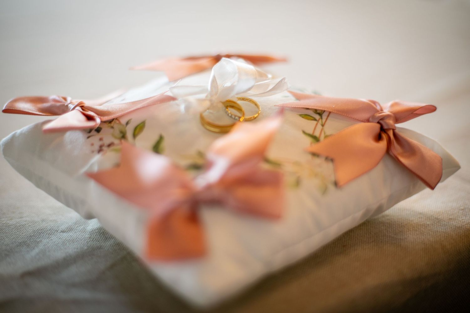 Pink ribbons adorn delicate white decorative party favors or gift bags arranged in a row.