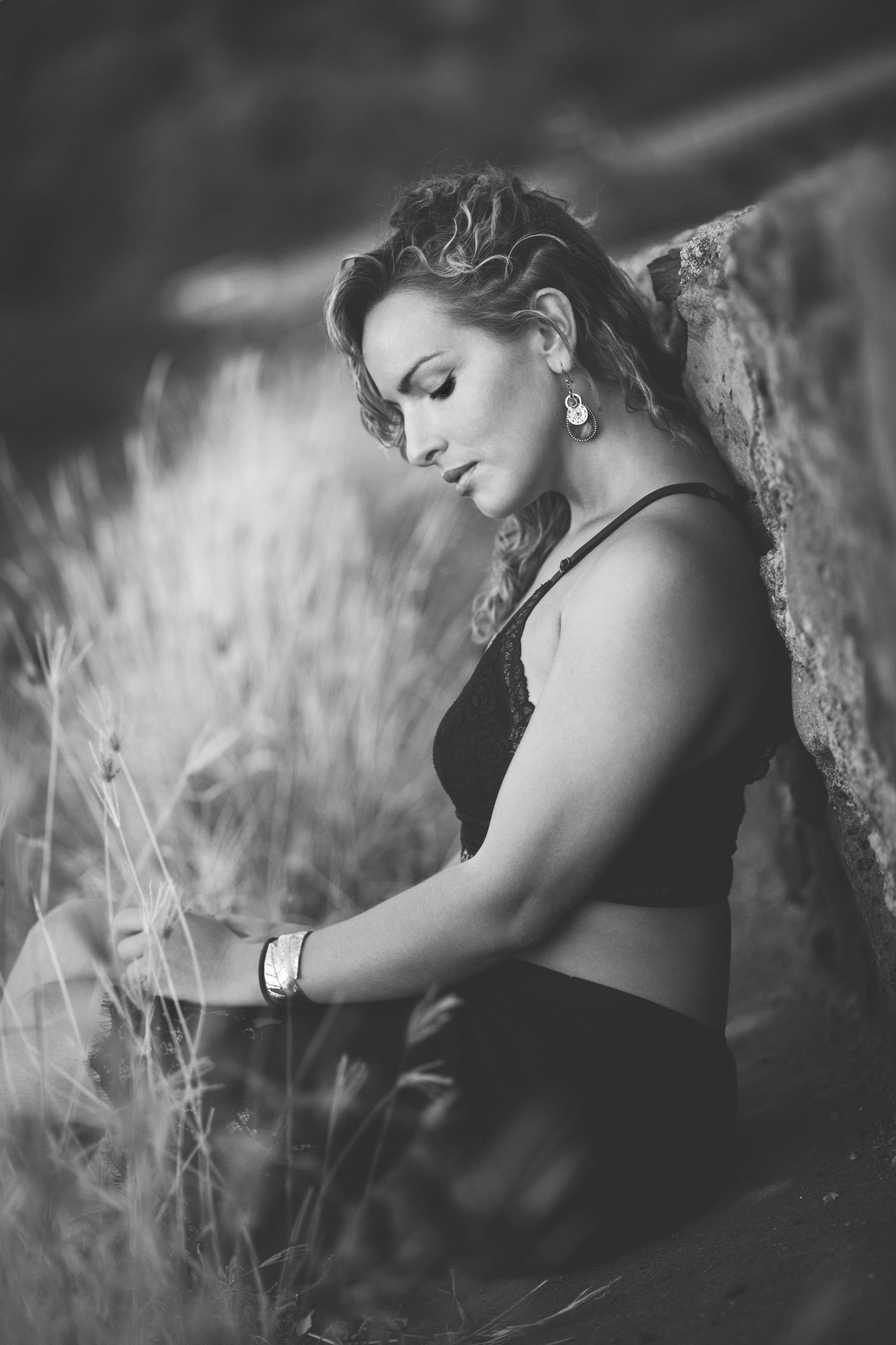 Portrait artistique en noir et blanc, à l'ile de la réunion avec une figure élégante dans de hautes herbes avec un éclairage doux.