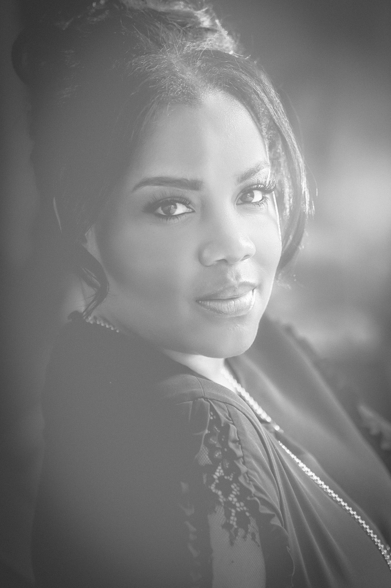 A series of black and white portraits capturing posed shots from different angles in moody lighting.