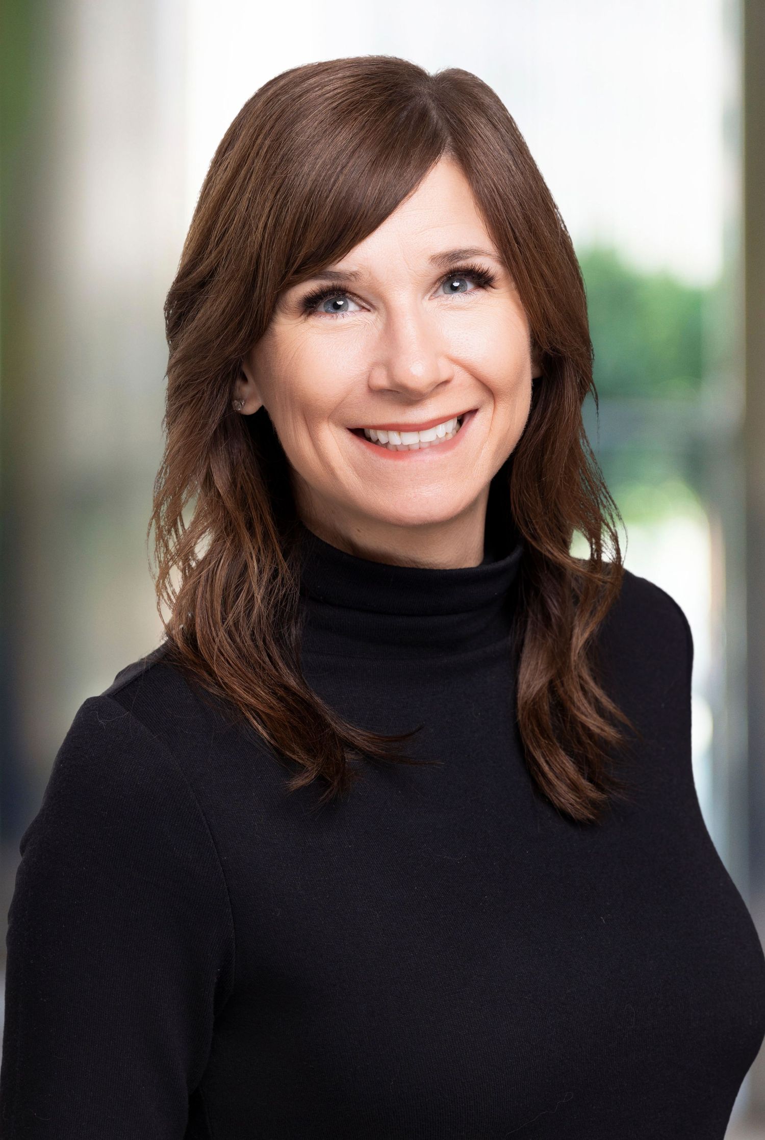 Professional head shot wearing black turtleneck against blurred background. Louisiana head shot photographer.