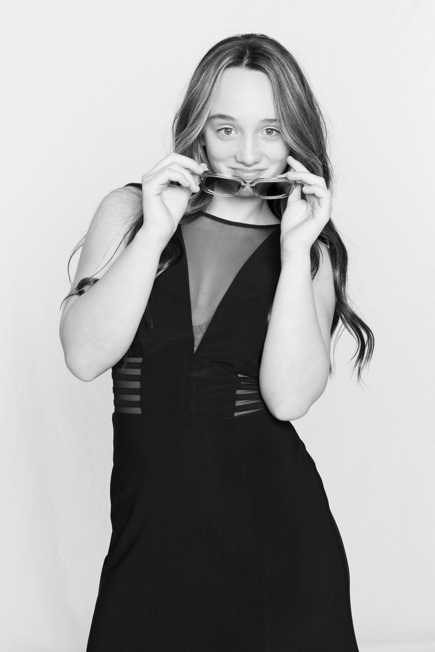 A series of four black and white portraits showing a person in a black dress against a white background.