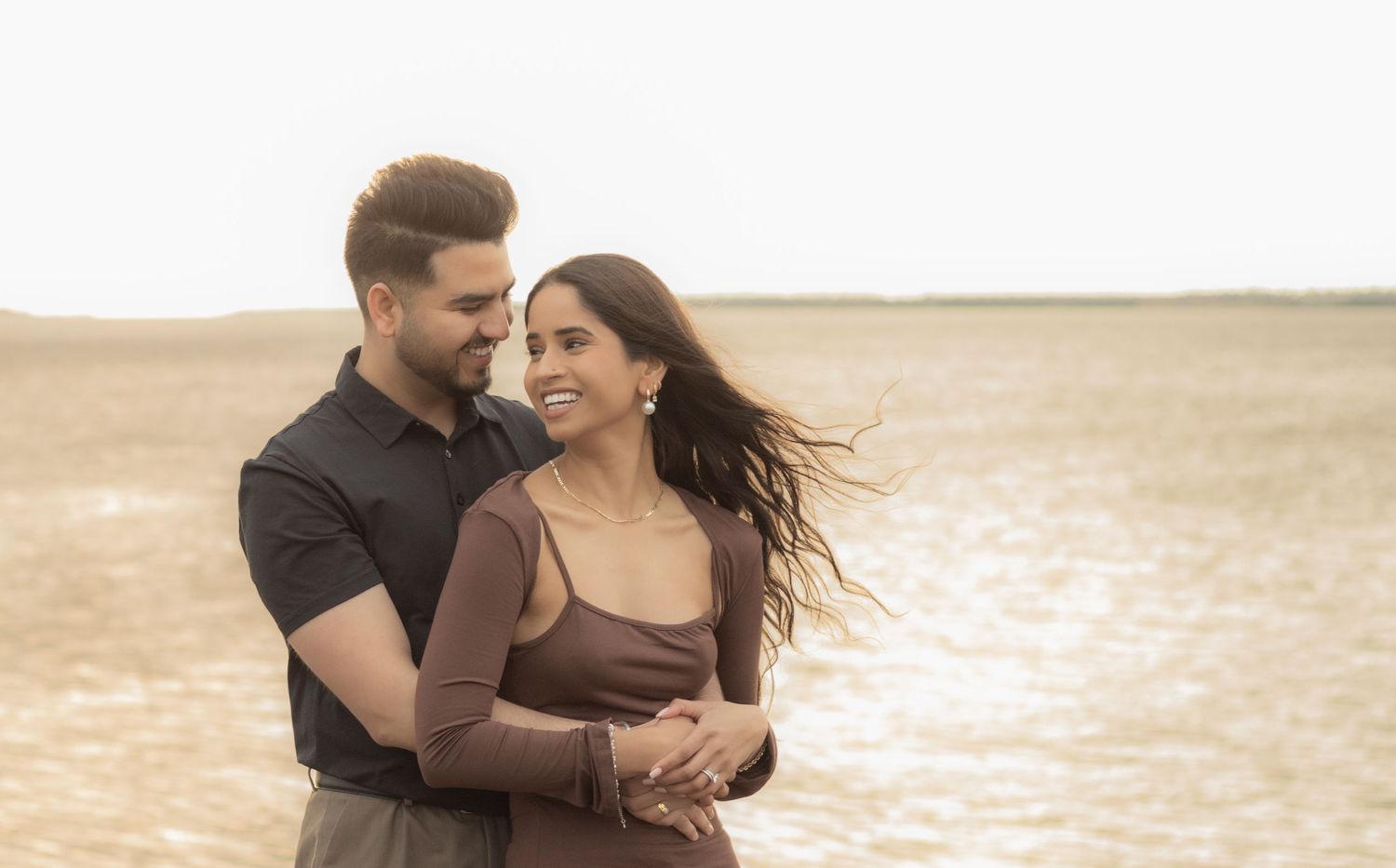 A couple sharing an intimate moment on the beach during golden hour.