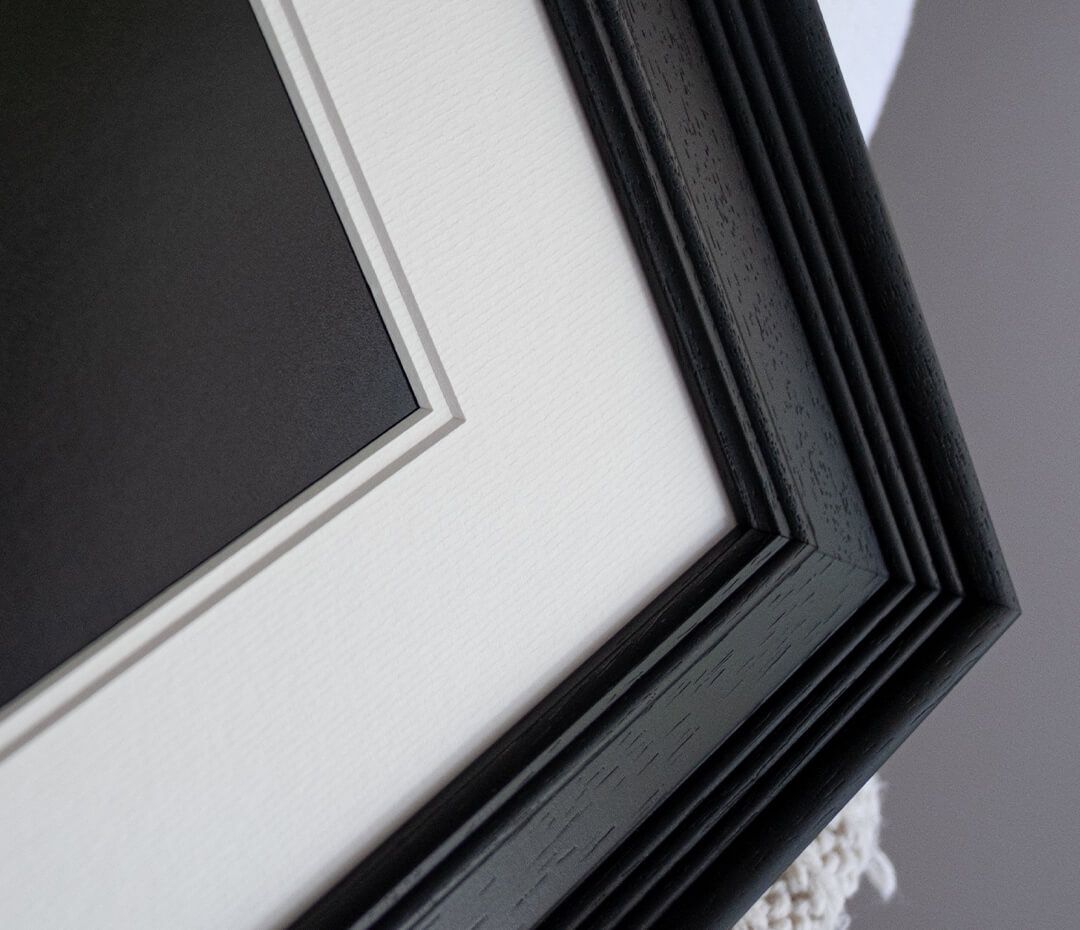 Close-up detail view of a silver metal railing against a dark background with strong diagonal lines and shadows.