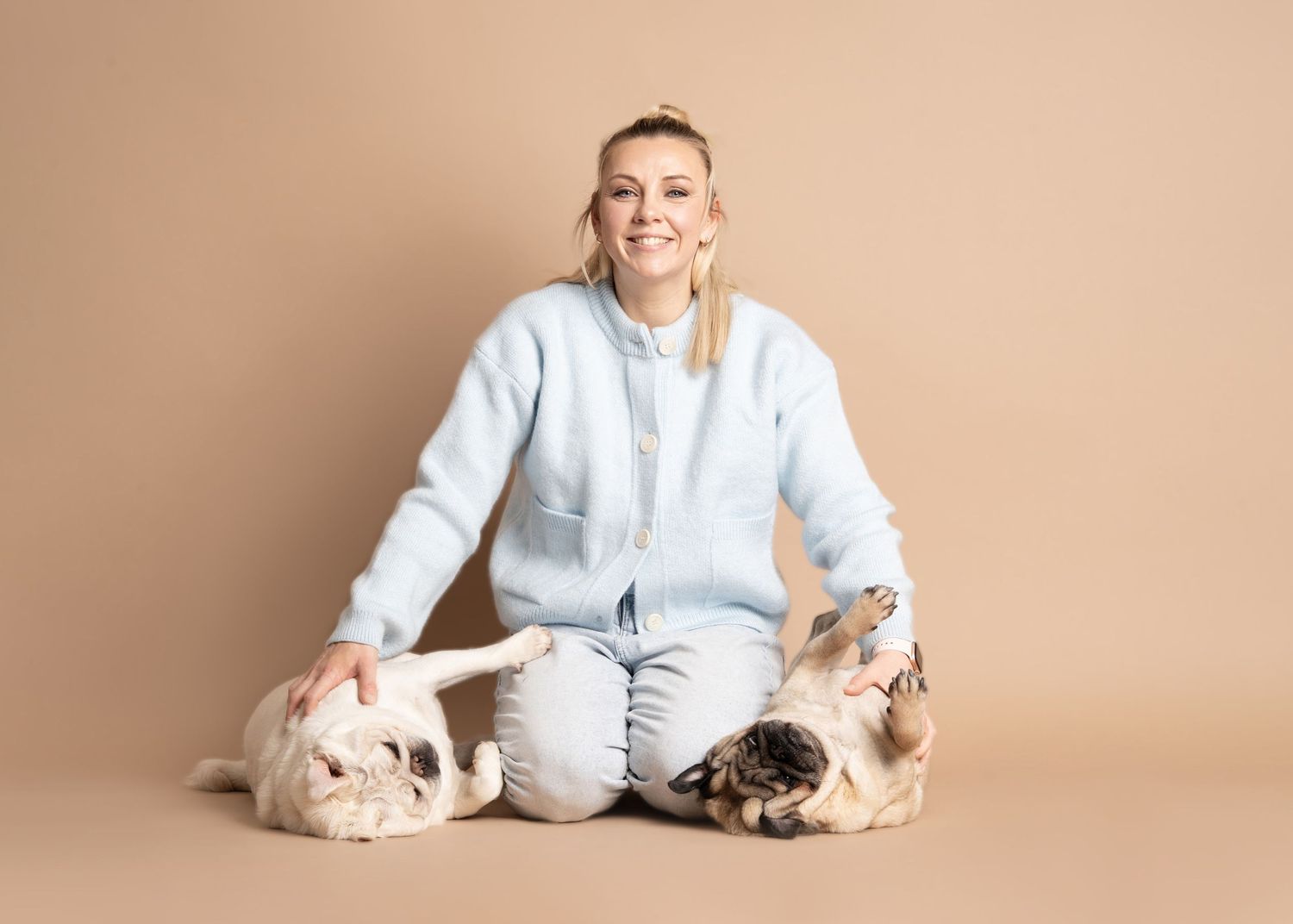 Panoramic photo series showing a person in light blue shirt posing with two sleeping French Bulldogs against beige background.