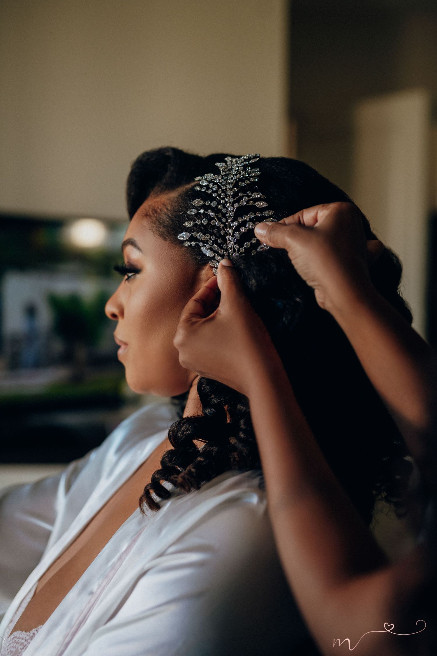 Close-up shot of ornate crystal hair accessory being placed during styling session.