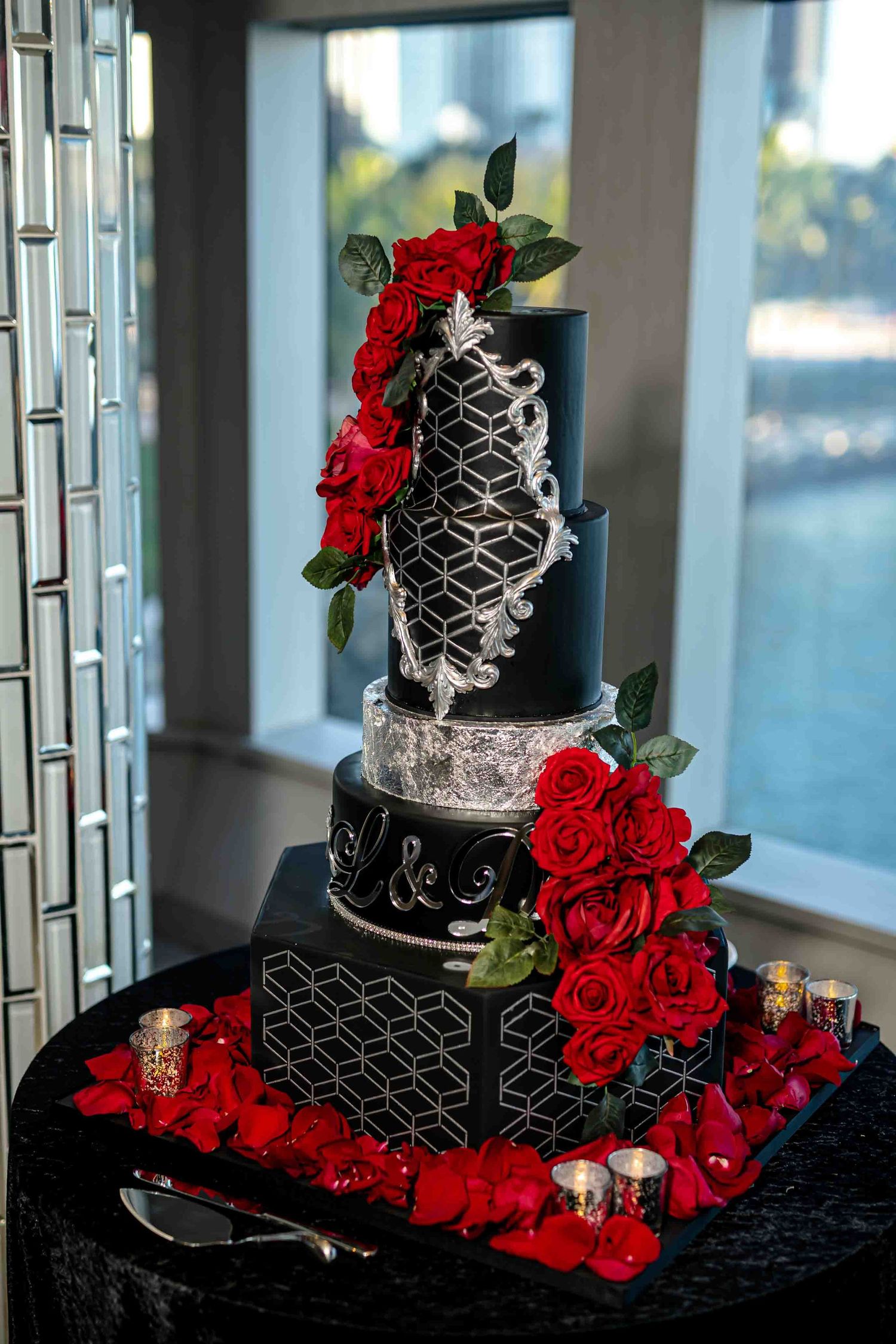 Black and silver geometric wedding cake decorated with cascading red roses and intricate patterns on the Seafair Mega Yacht in Miami.
