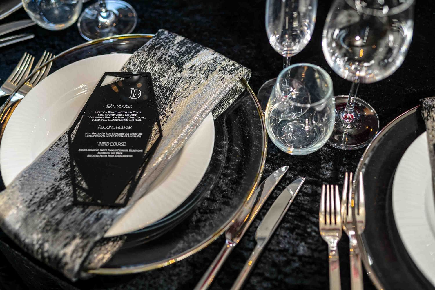 Formal place setting with marble-effect charger plate, silverware and elegant menu card on the Seafair Mega Yacht in Miami.