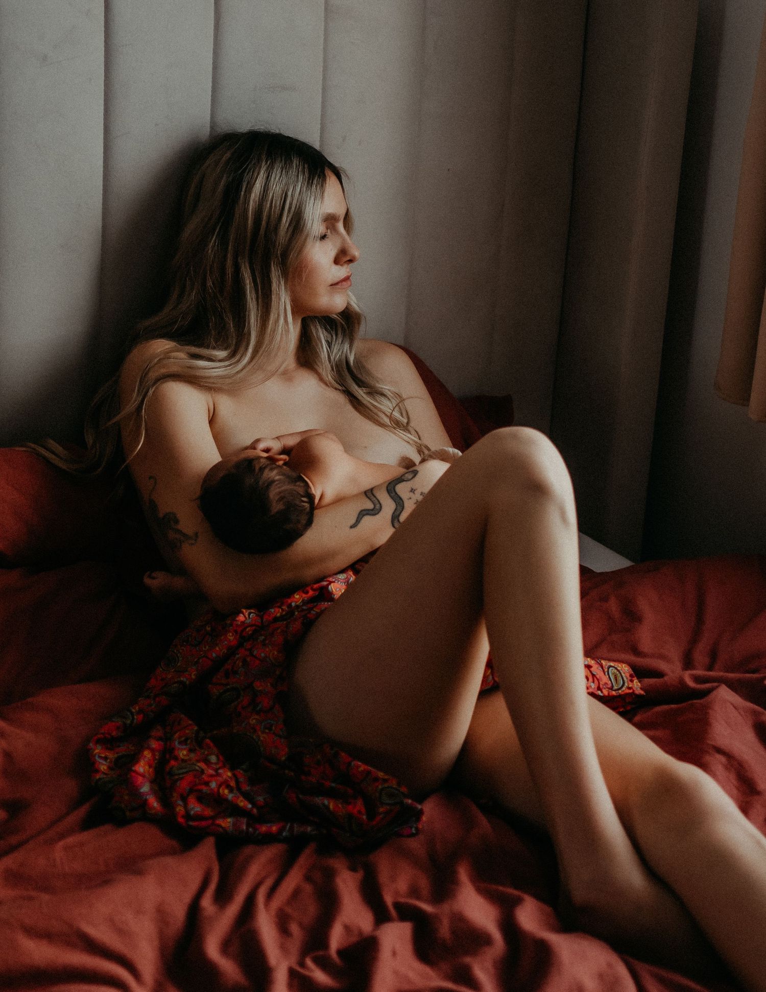 A mother nursing her new-born during an in home new-born photo shoot in Kent