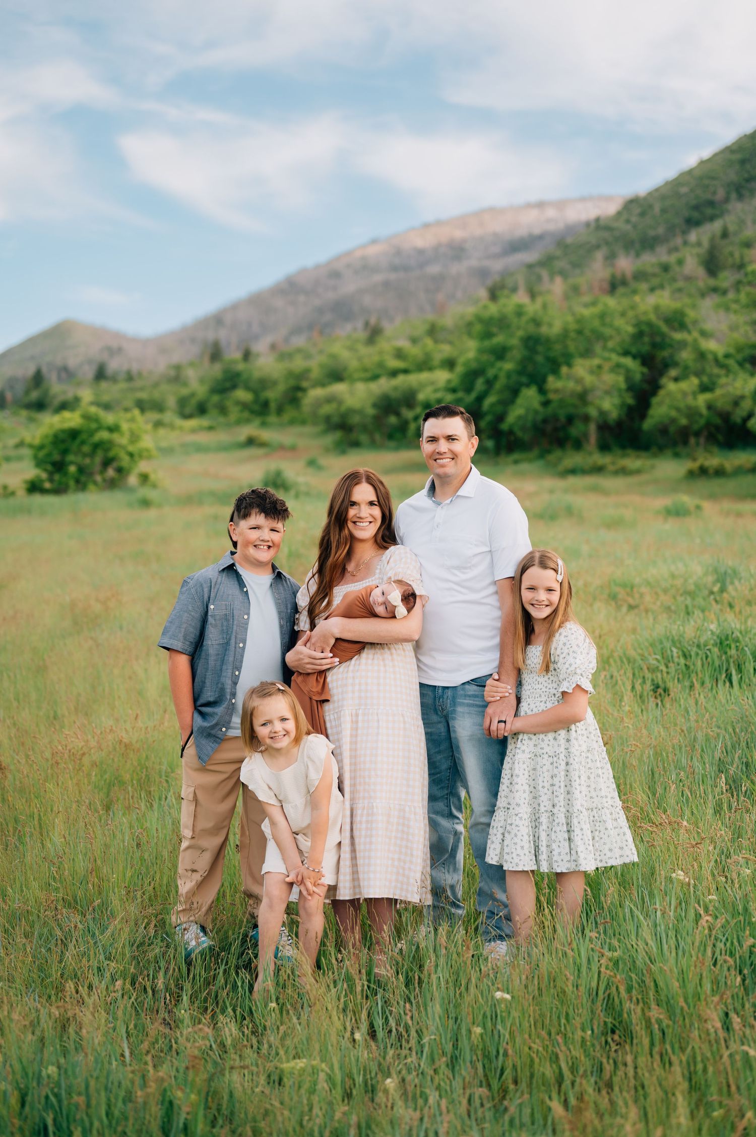 Family portrait in green mountain meadow during summer.