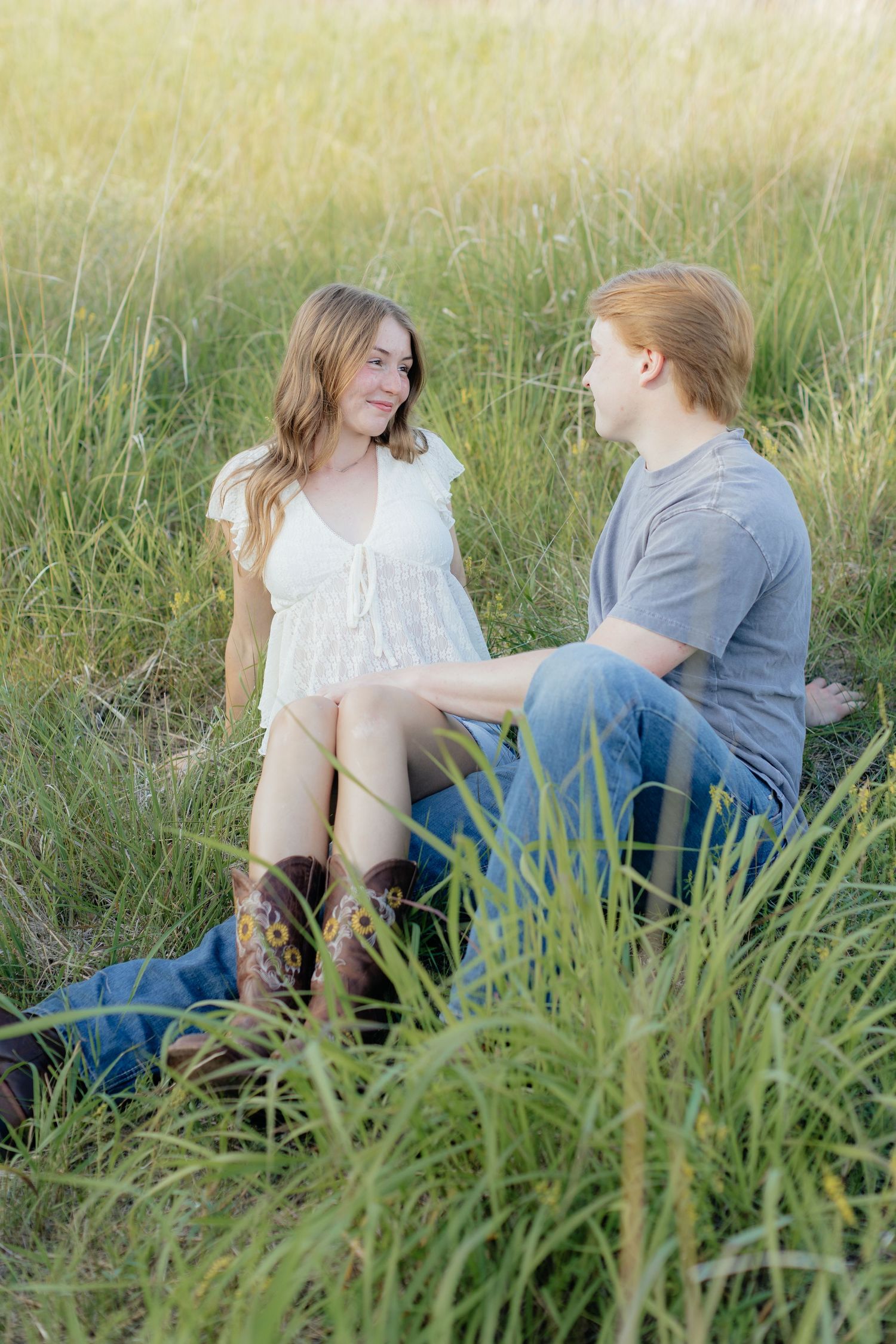 Romantic photo of a couple embracing on a hilltop at Prairie Bluffs, surrounded by open fields and wide Minnesota skies.