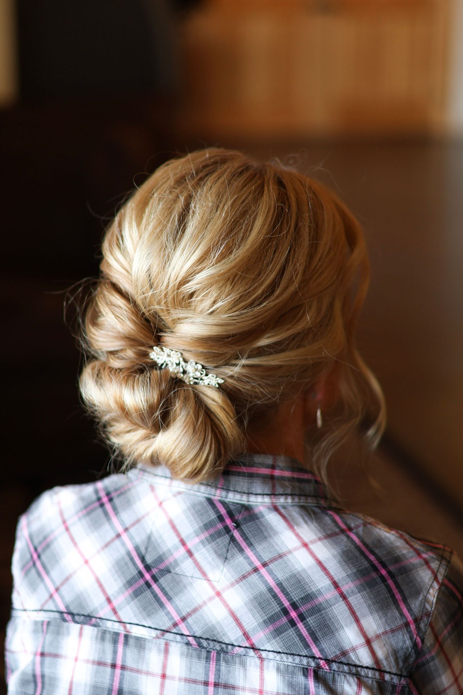 Bride’s elegant updo hairstyle adorned with delicate floral accents at Lilacs at the Northern Lights Ballroom, captured in soft light