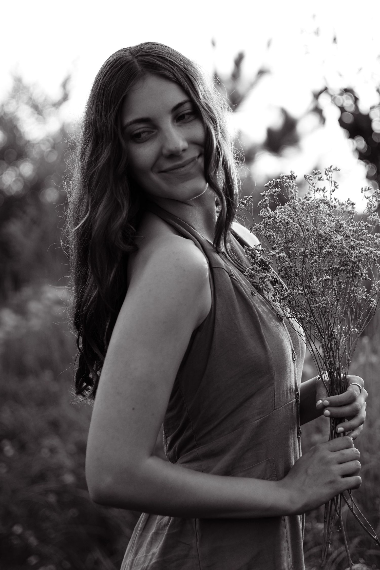 High school senior standing in a golden field in St. Michael, MN, surrounded by tall grasses for a relaxed shoot