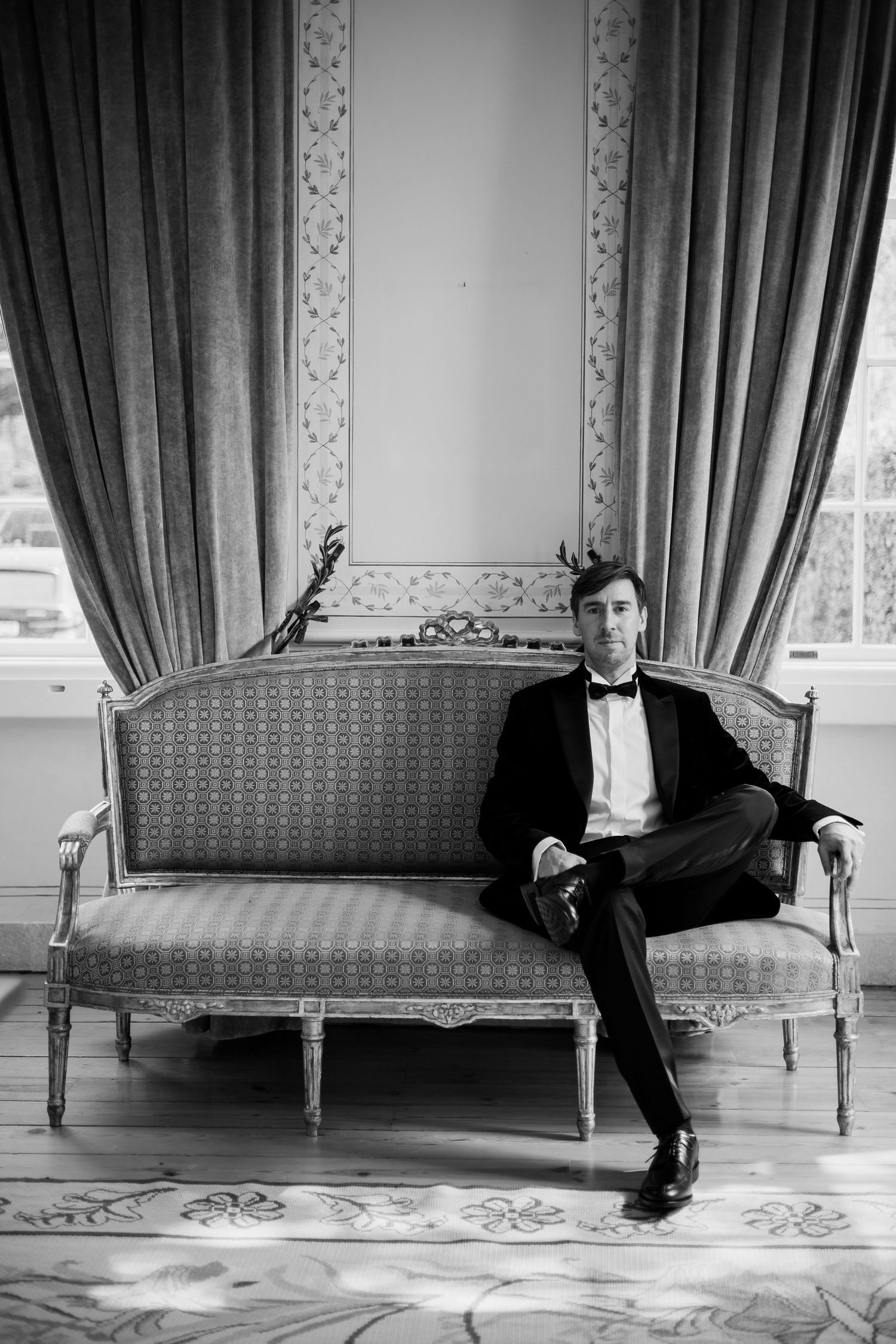 Classic black and white photo of formal attire against an elegant vintage settee.