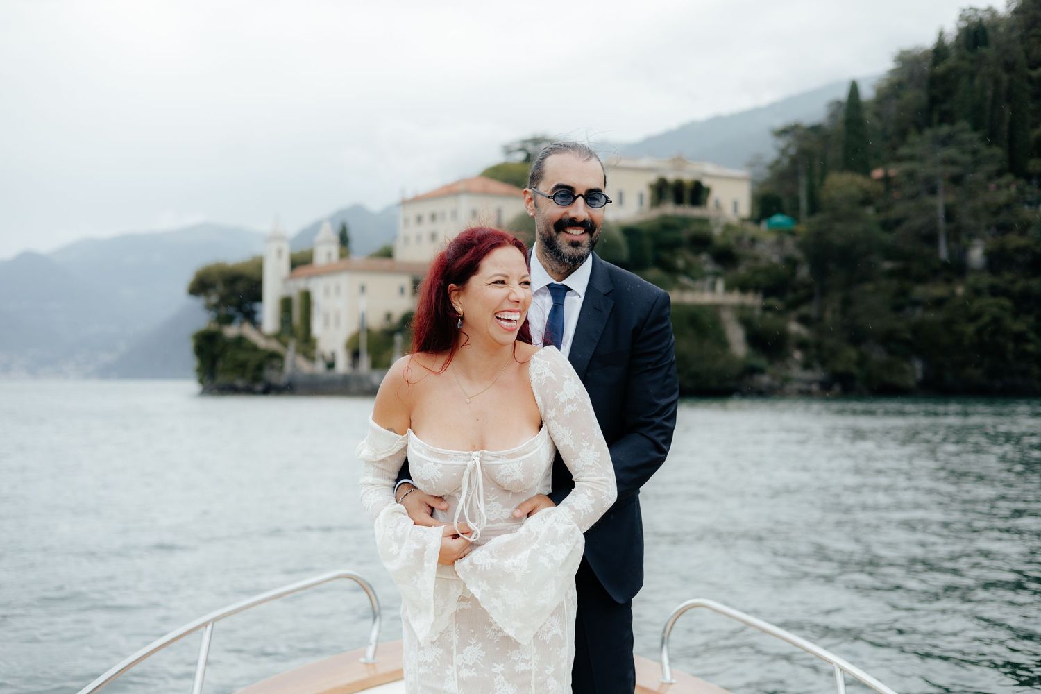 A romantic boat ride featuring a couple in wedding attire against a scenic lakeside backdrop.