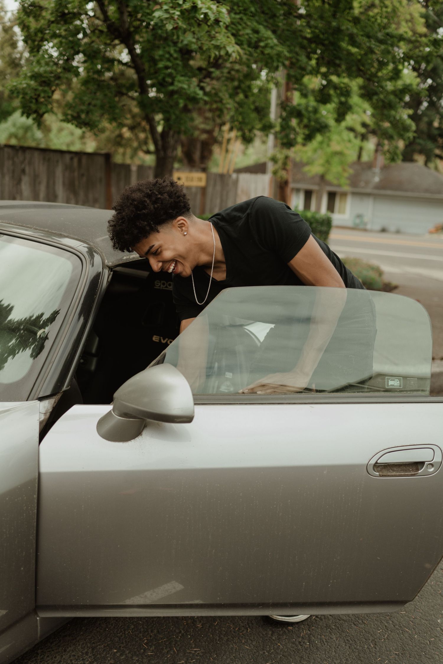 Person leaning into car window during vehicle inspection.