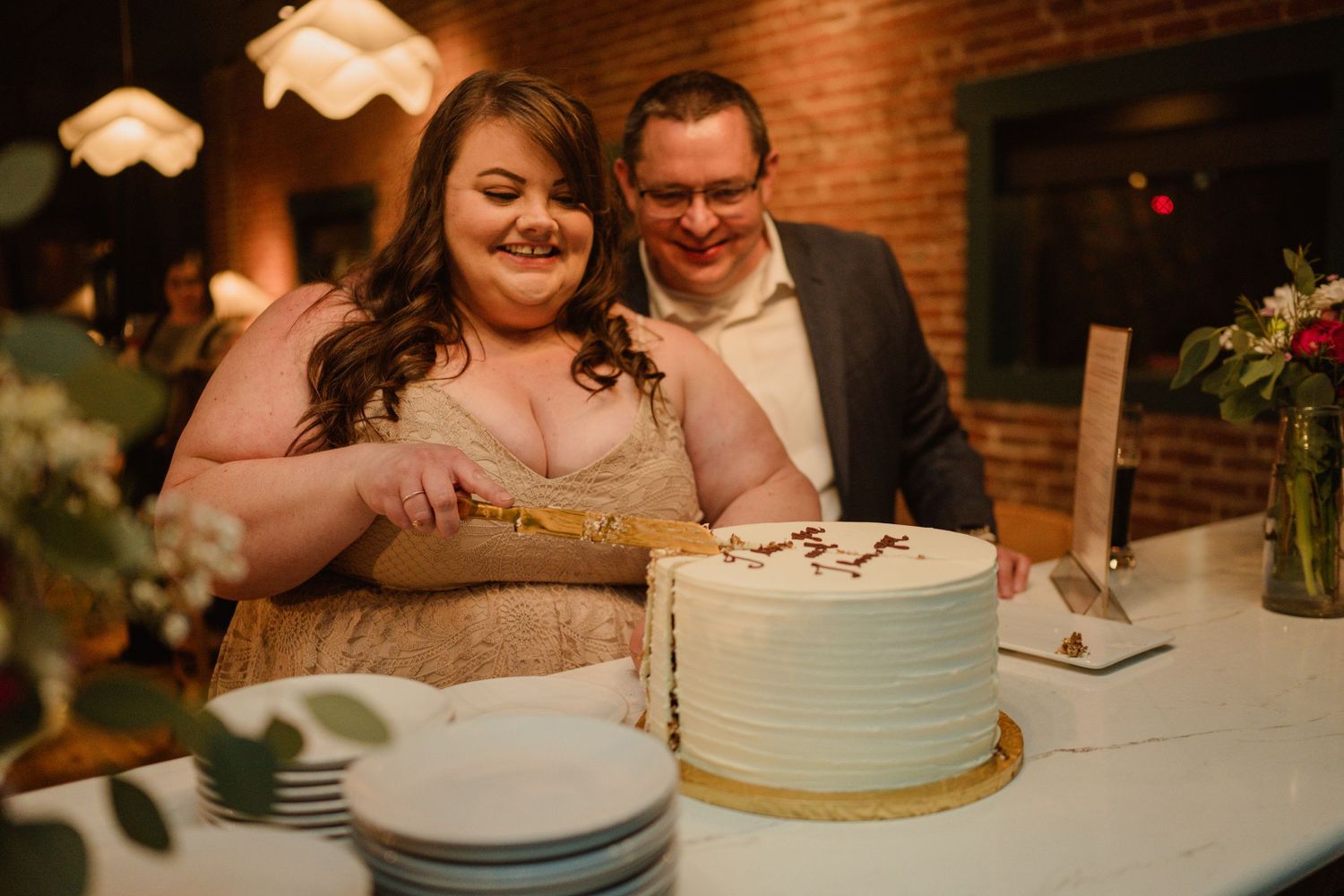 A couple enjoys a lighthearted moment while cutting their light blue wedding cake.