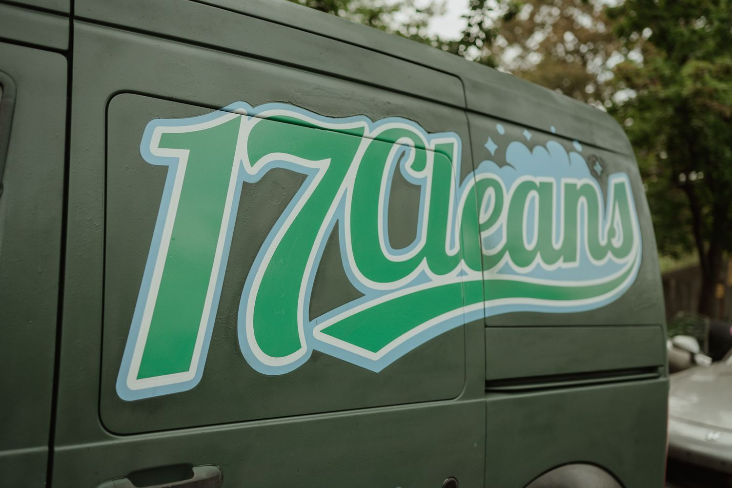 Green '17 Cleans' logo decal on side of dark van.
