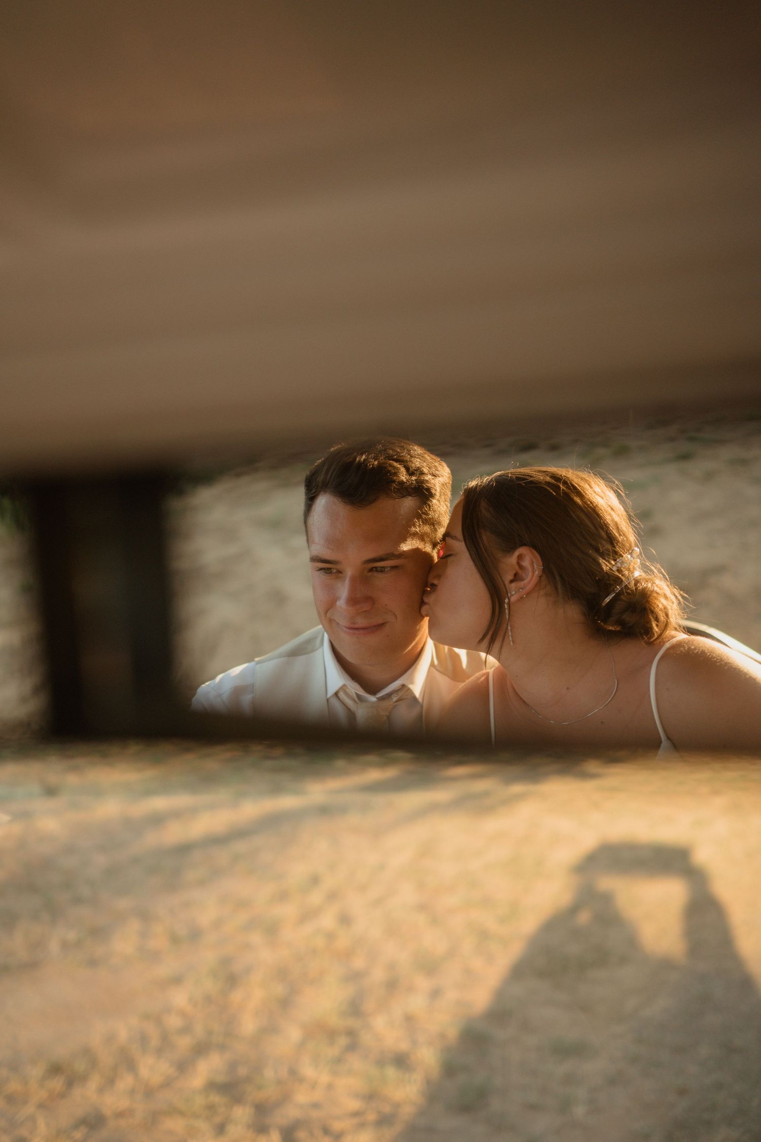 An intimate close-up portrait of a couple bathed in warm sunset light.