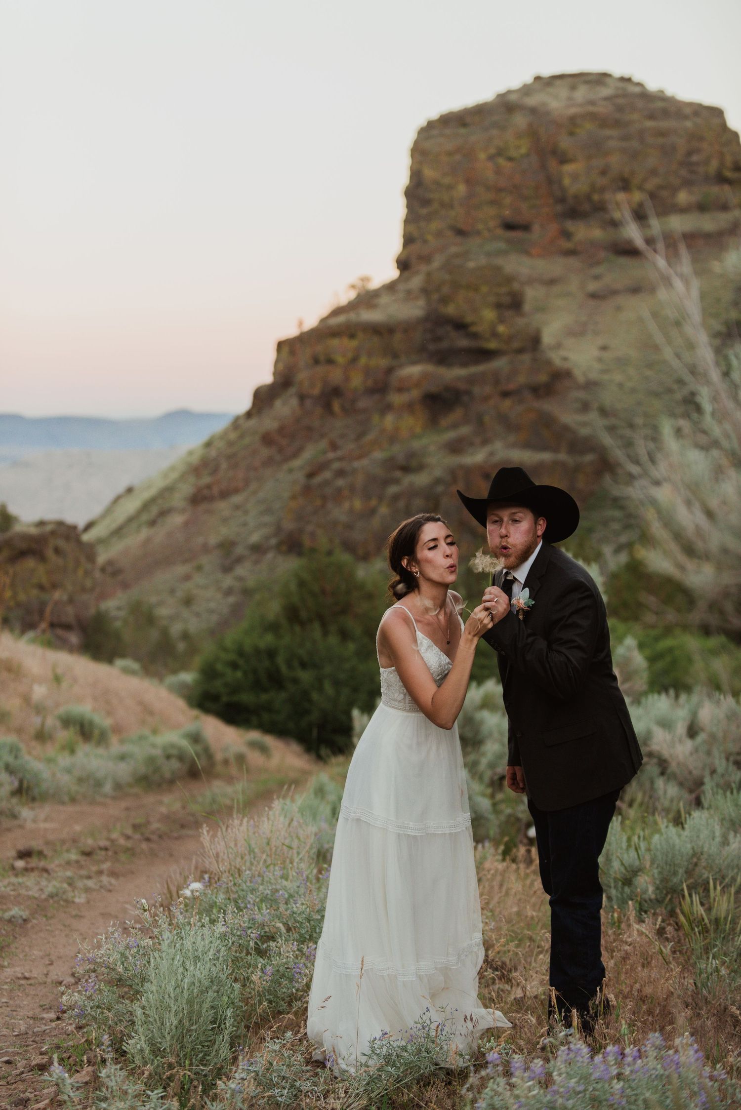 A romantic dance moment between newlyweds among desert sagebrush and mountains.