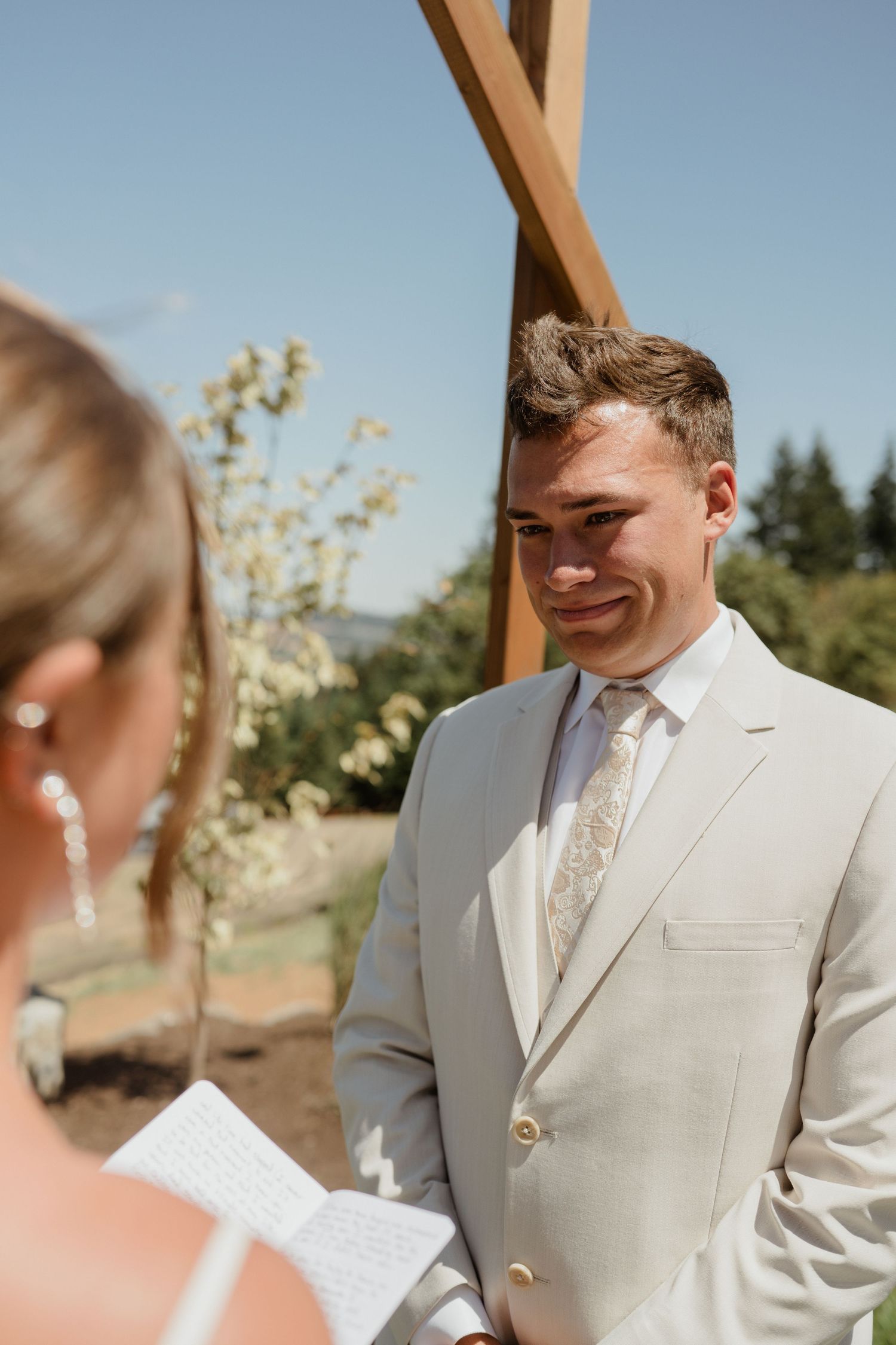 An outdoor wedding ceremony with modern rustic decor and string lights overhead.