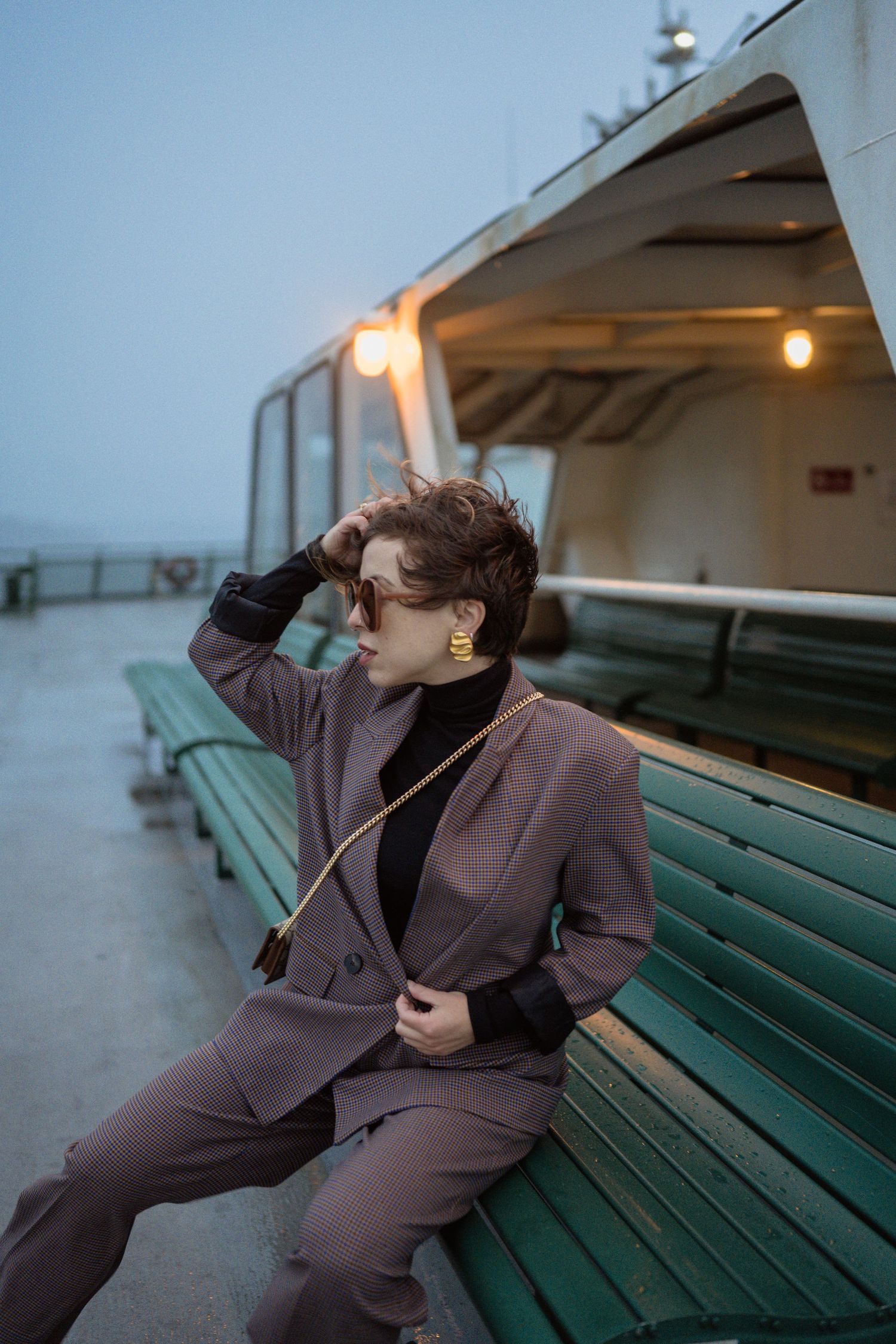 A moody portrait on a ferry bench during blue hour.