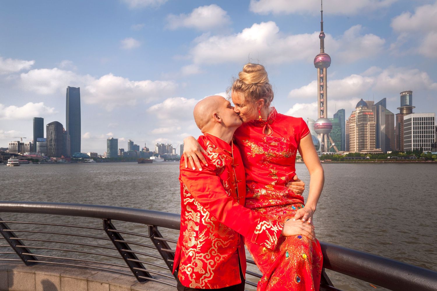 Caucasian couple dressed in Chinese outfits at the Bund in Shanghai.