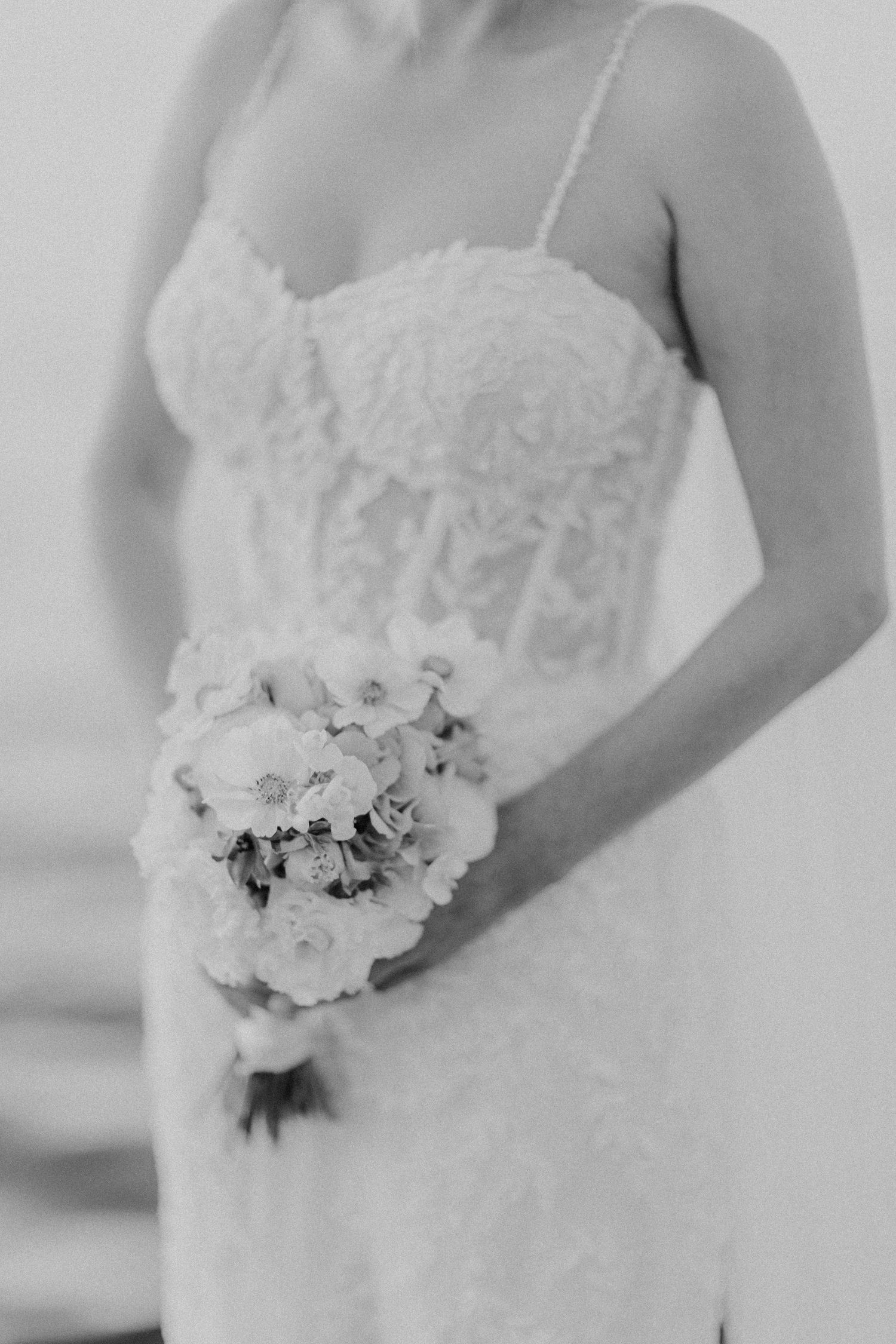 Detailaufnahme der Braut in weißem Spitzenmiederkleid mit klassischem weißem Blumenstrauß in Hamburg.
