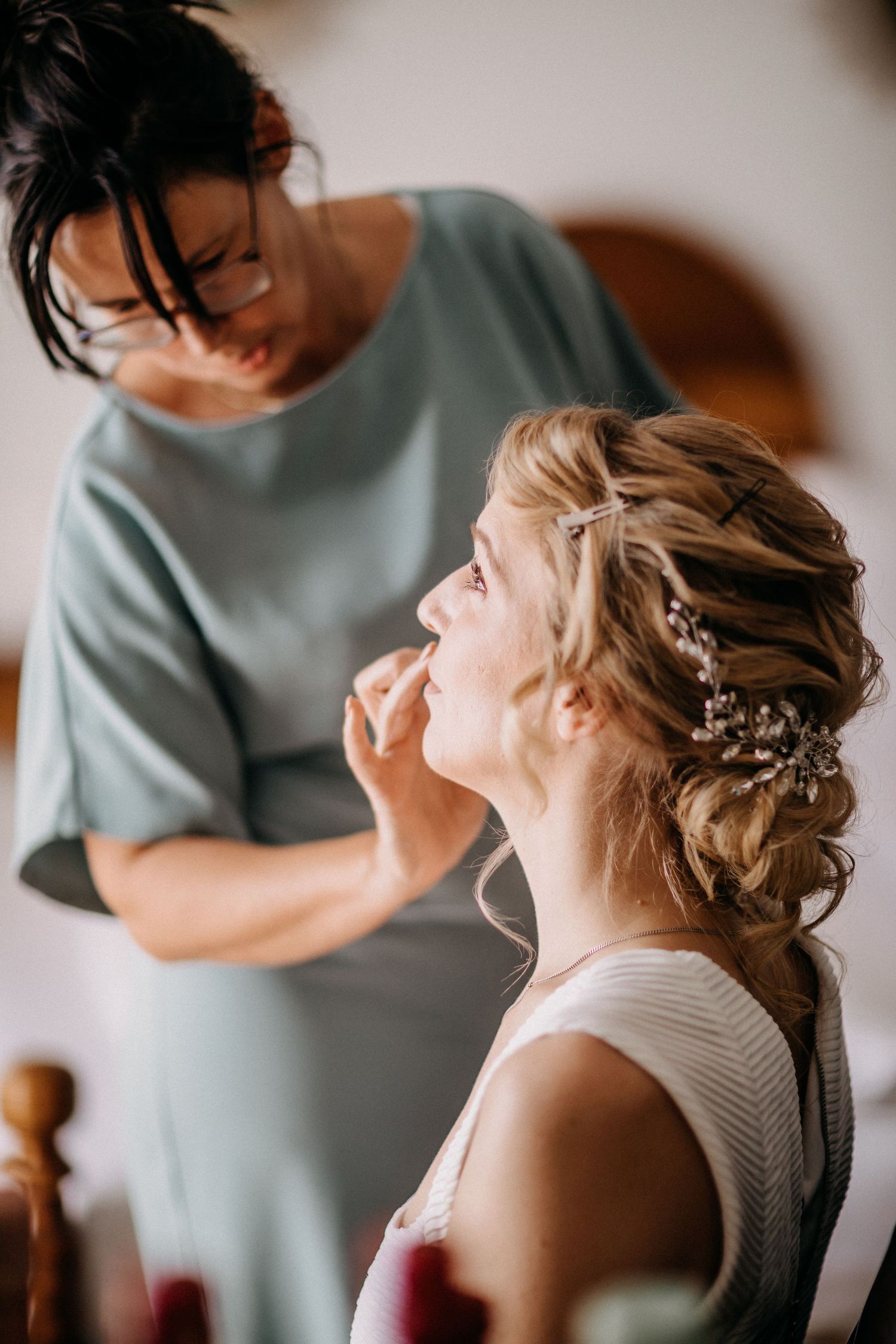Hochzeitsvorbereitungsszene mit Brauthaarstyling im natürlichen Licht.