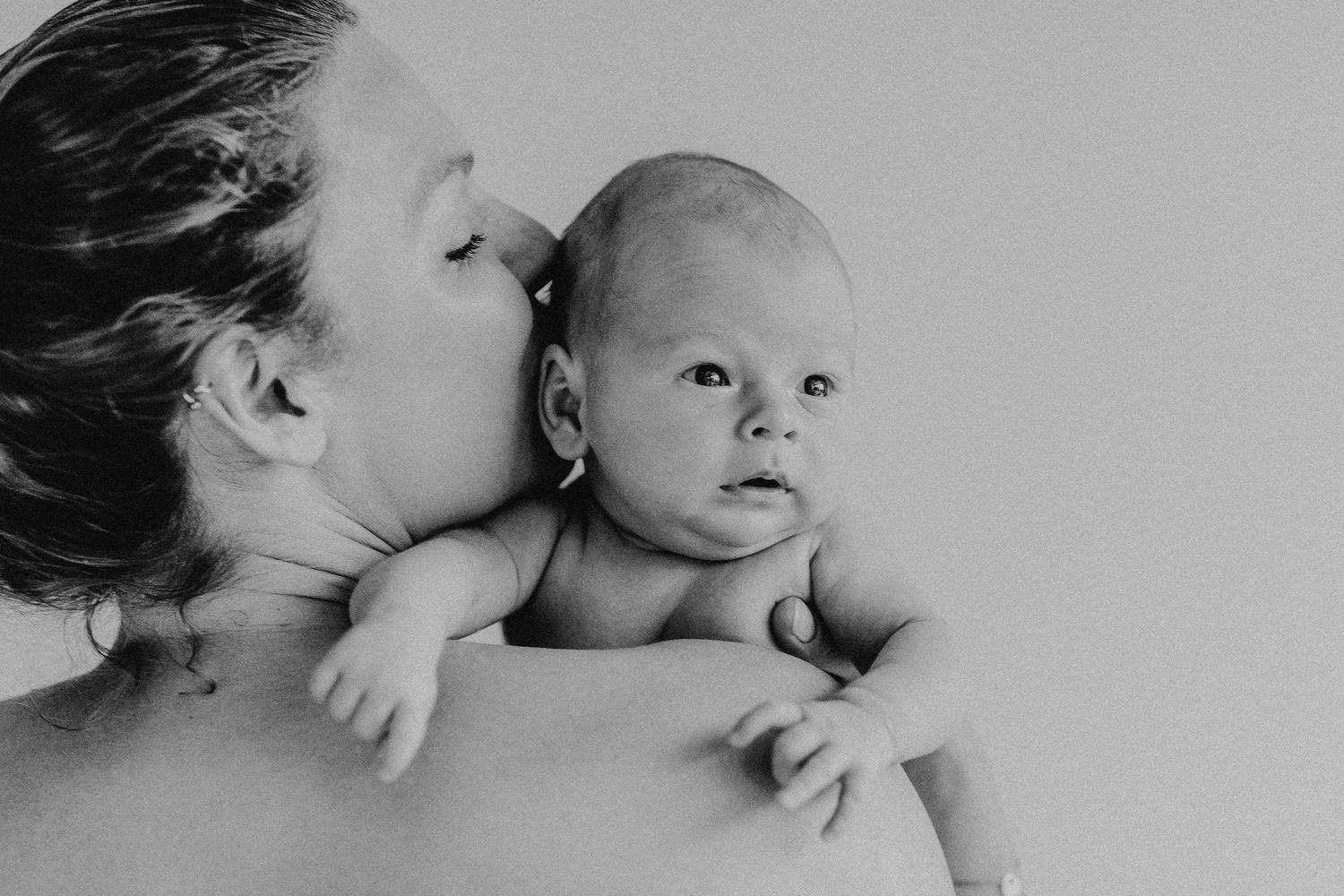 Intimes Schwarz-Weiß-Porträt, das einen sanften Moment mit einem Baby einfängt in Wolfsburg.