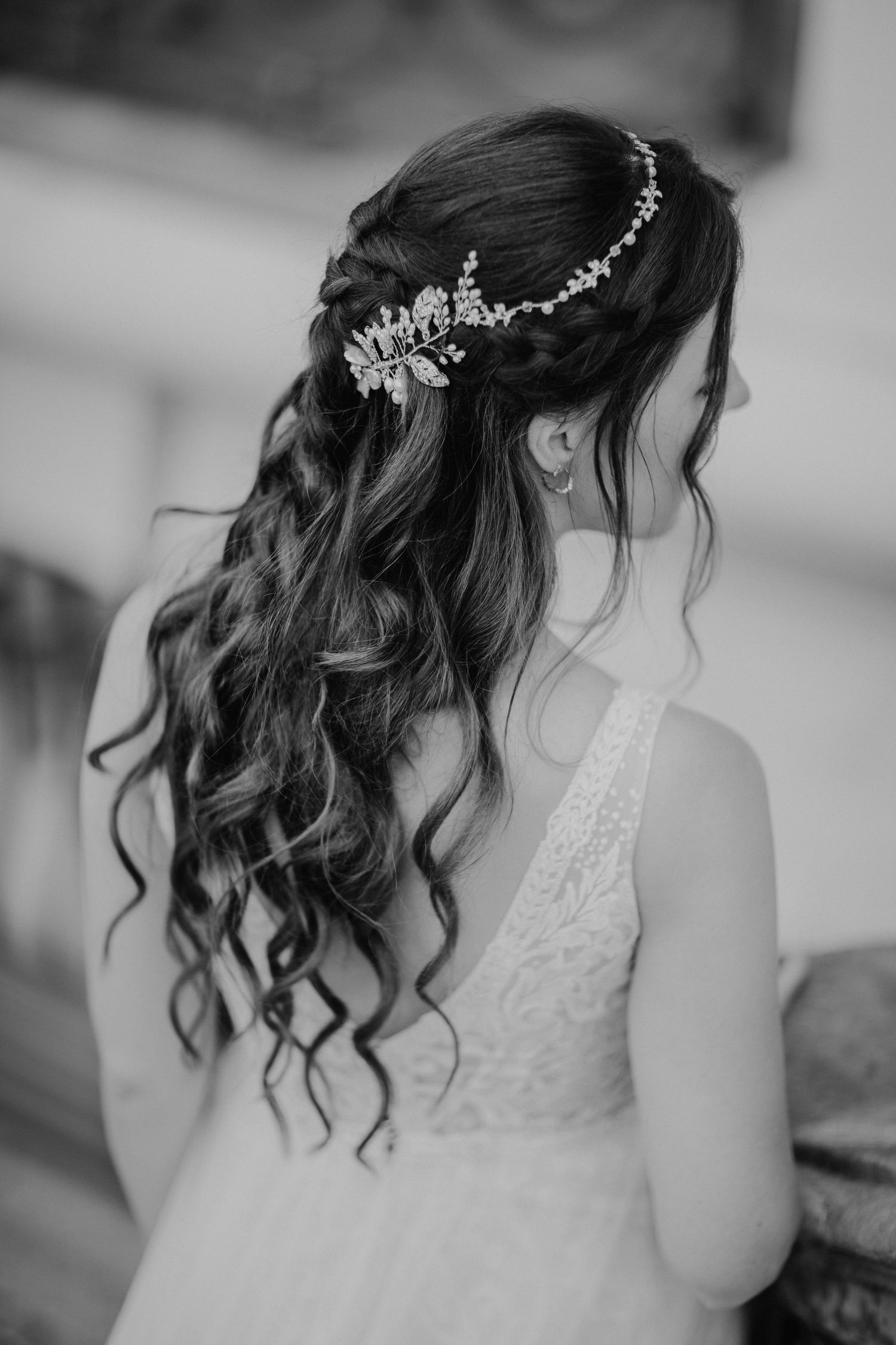 Elegante Brautfrisur mit Locken und Kristallhaarschmuck in Schwarz und Weiß.
