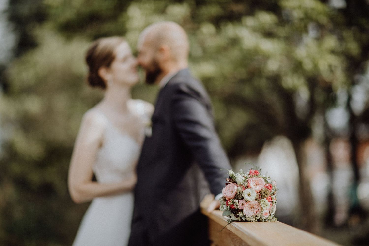 Soft-Focus-Hochzeitspaar umarmt sich in einem Garten im Freien in Helmstedt.