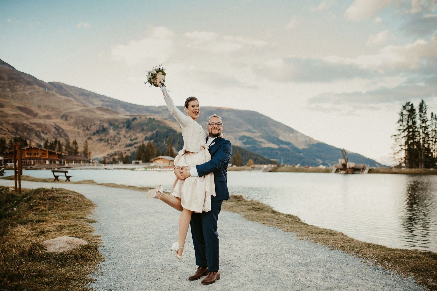 Ein romantisches Hochzeitsfotoshooting im Freien an einem malerischen Bergsee mit dramatischer Bergkulisse in Österreich.