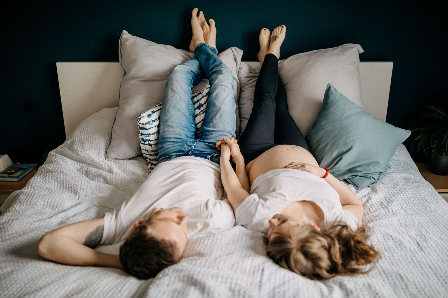 Zwei Menschen entspannen sich zusammen auf dem Bett mit Kissen und Decken.