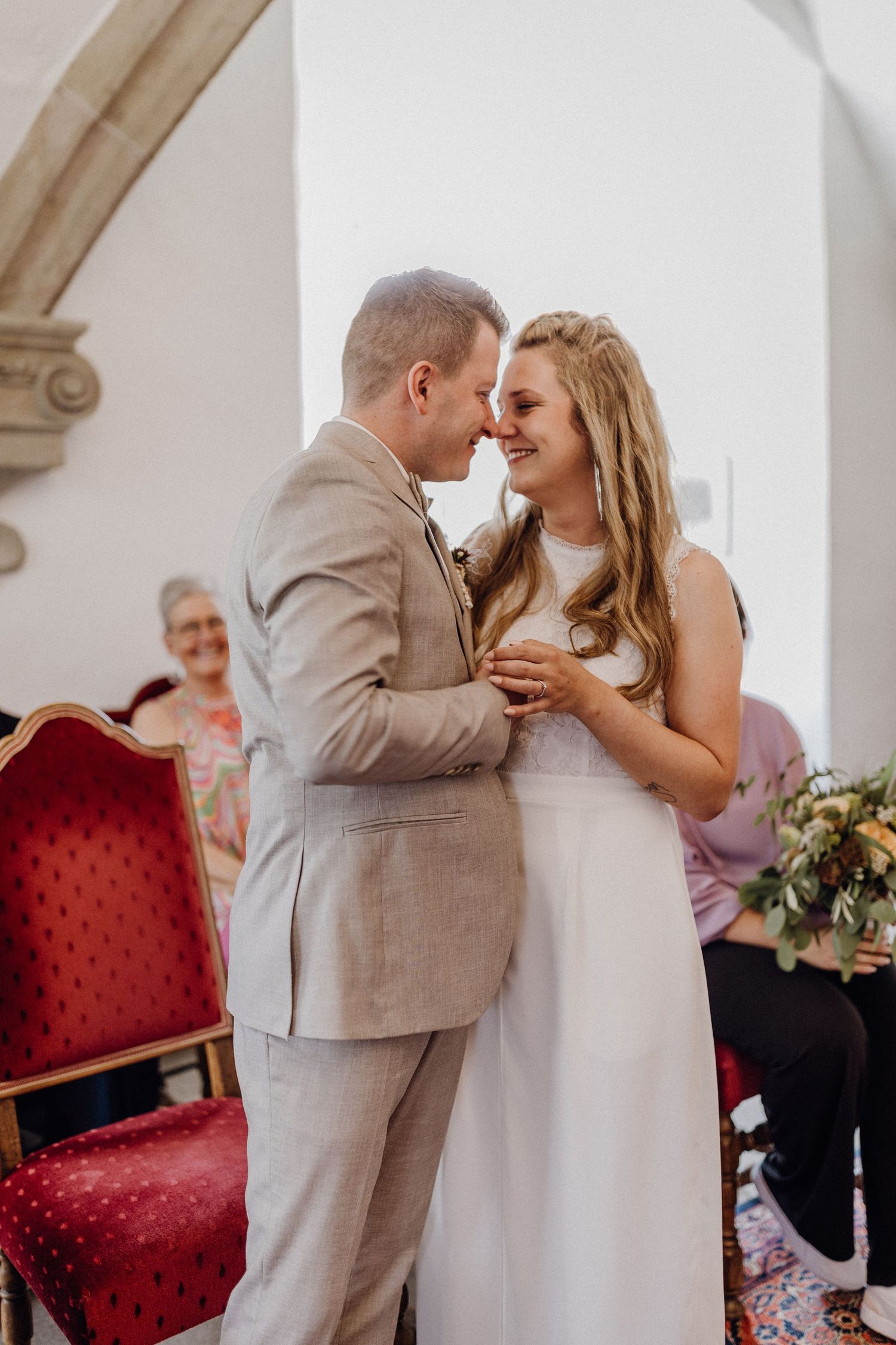 Intimer Moment zwischen dem Hochzeitspaar, das einen zärtlichen Moment während ihrer Zeremonie teilt.