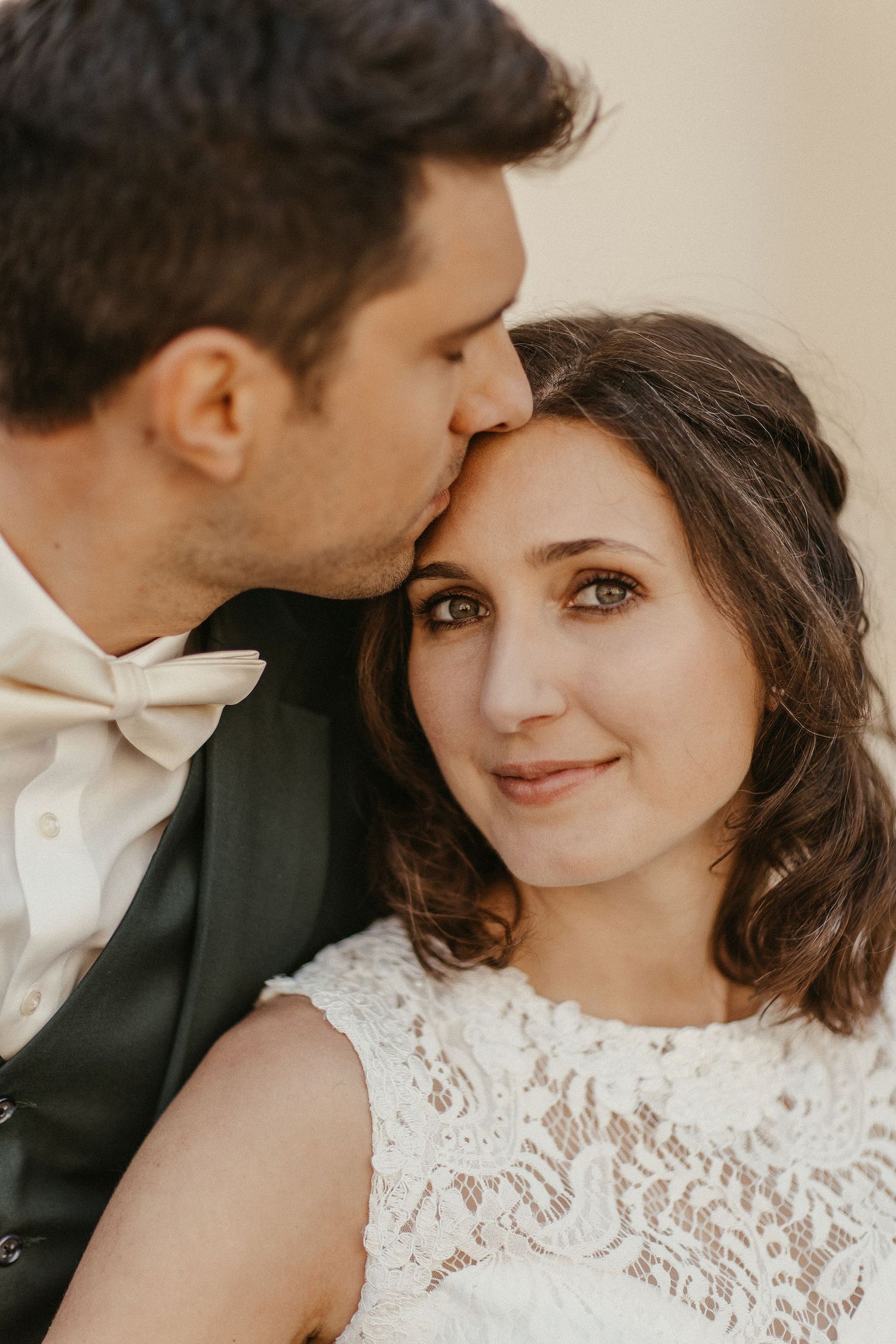 Nahaufnahme des romantischen Moments zwischen dem Brautpaar in traditioneller Hochzeitskleidung.
