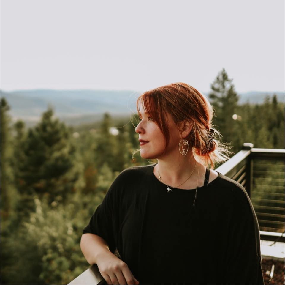 Portrait against natural mountain landscape with evergreen trees at sunset.