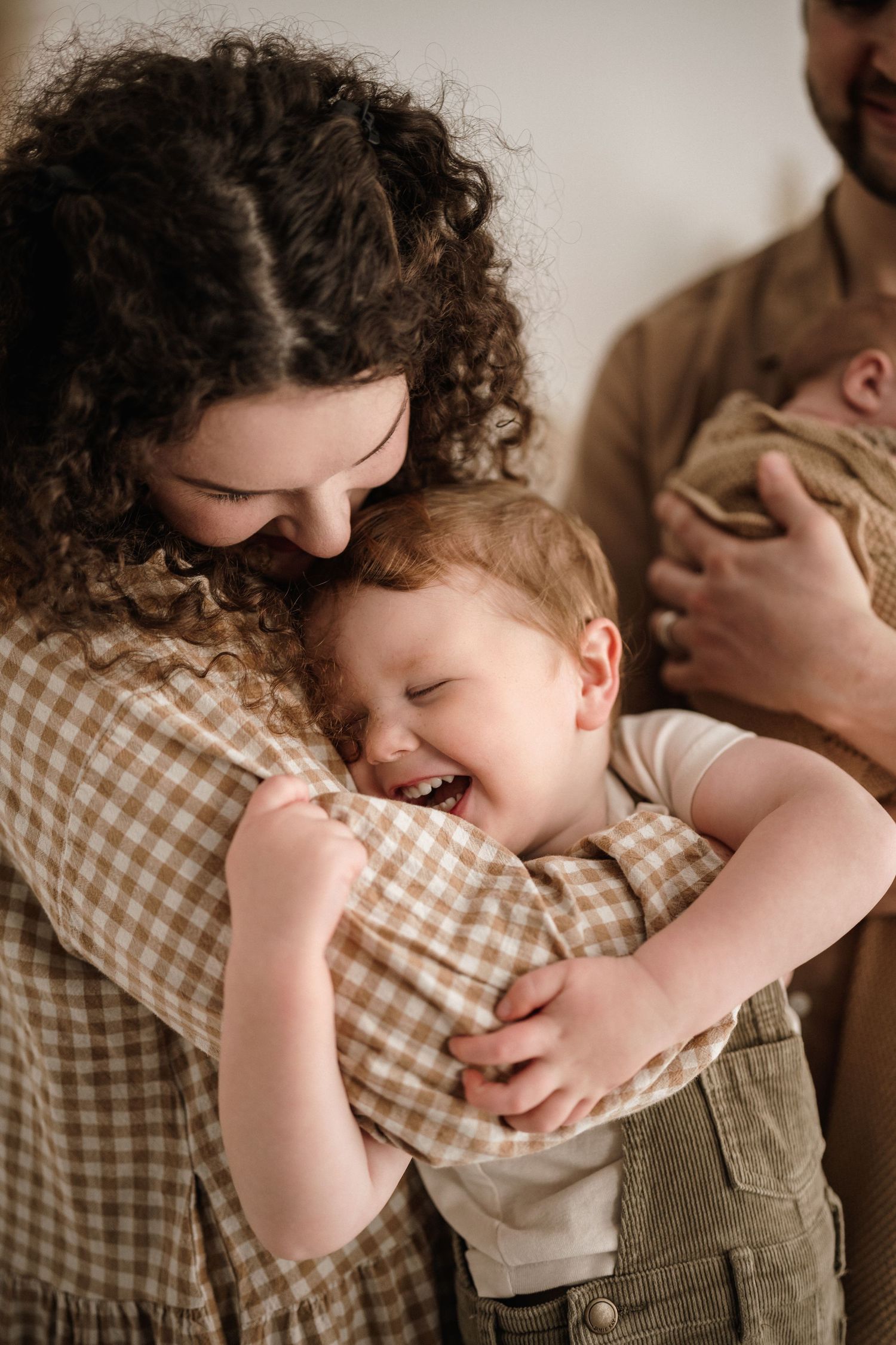 A sequence showing a toddler in a checkered shirt laughing and hiding face in a joyful, playful moment.