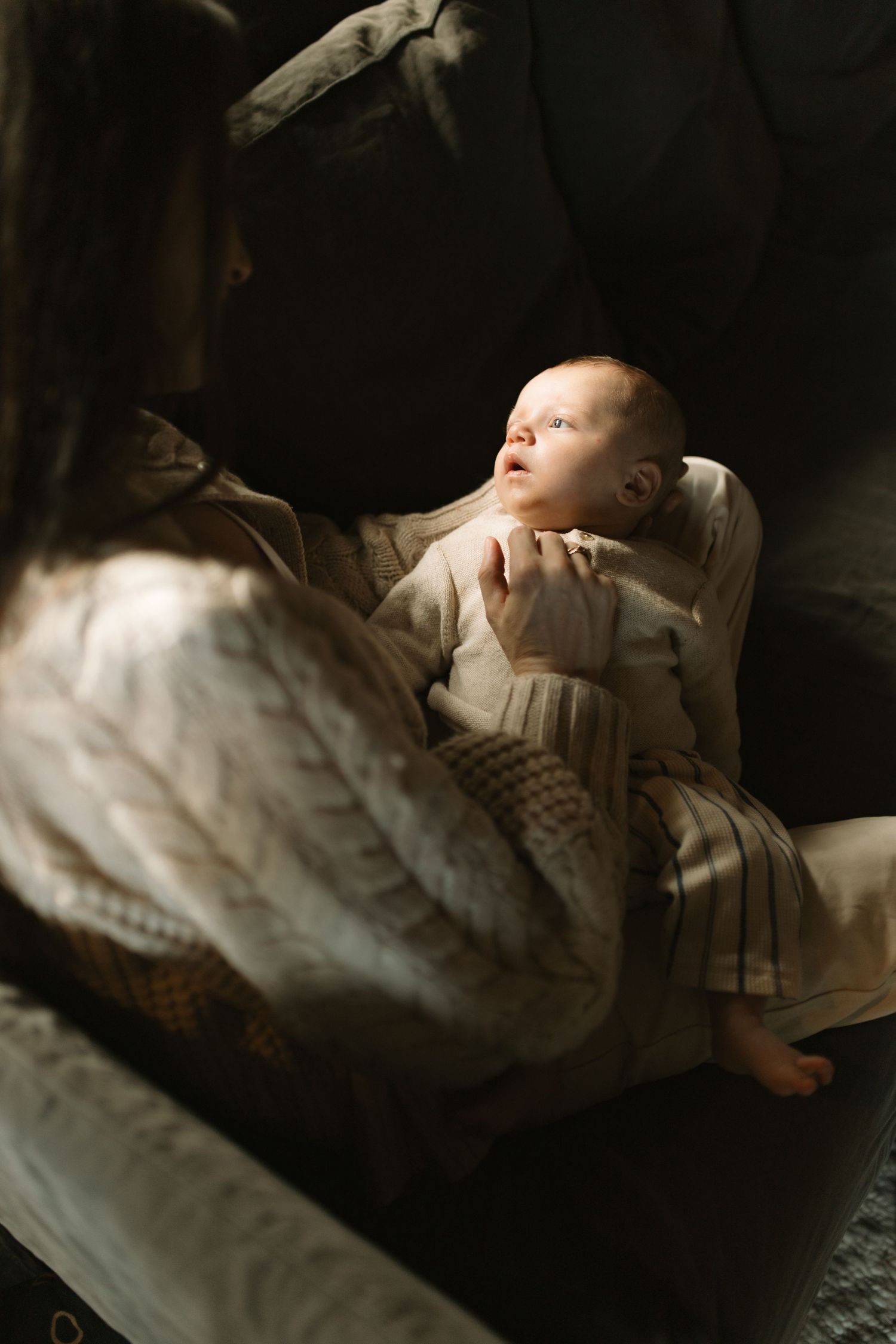 fine art photograph of newborn baby with his mother in the natural window light of their home