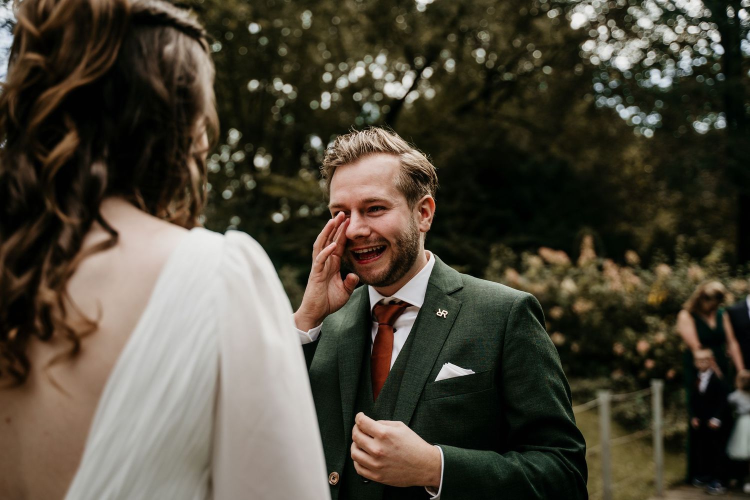 Candid moment of joyful laughter during outdoor wedding ceremony.