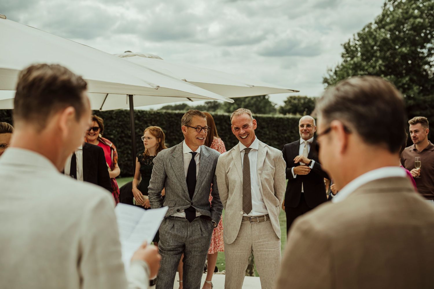 Wedding guests gathered outdoors under cloudy skies during a casual summer celebration.